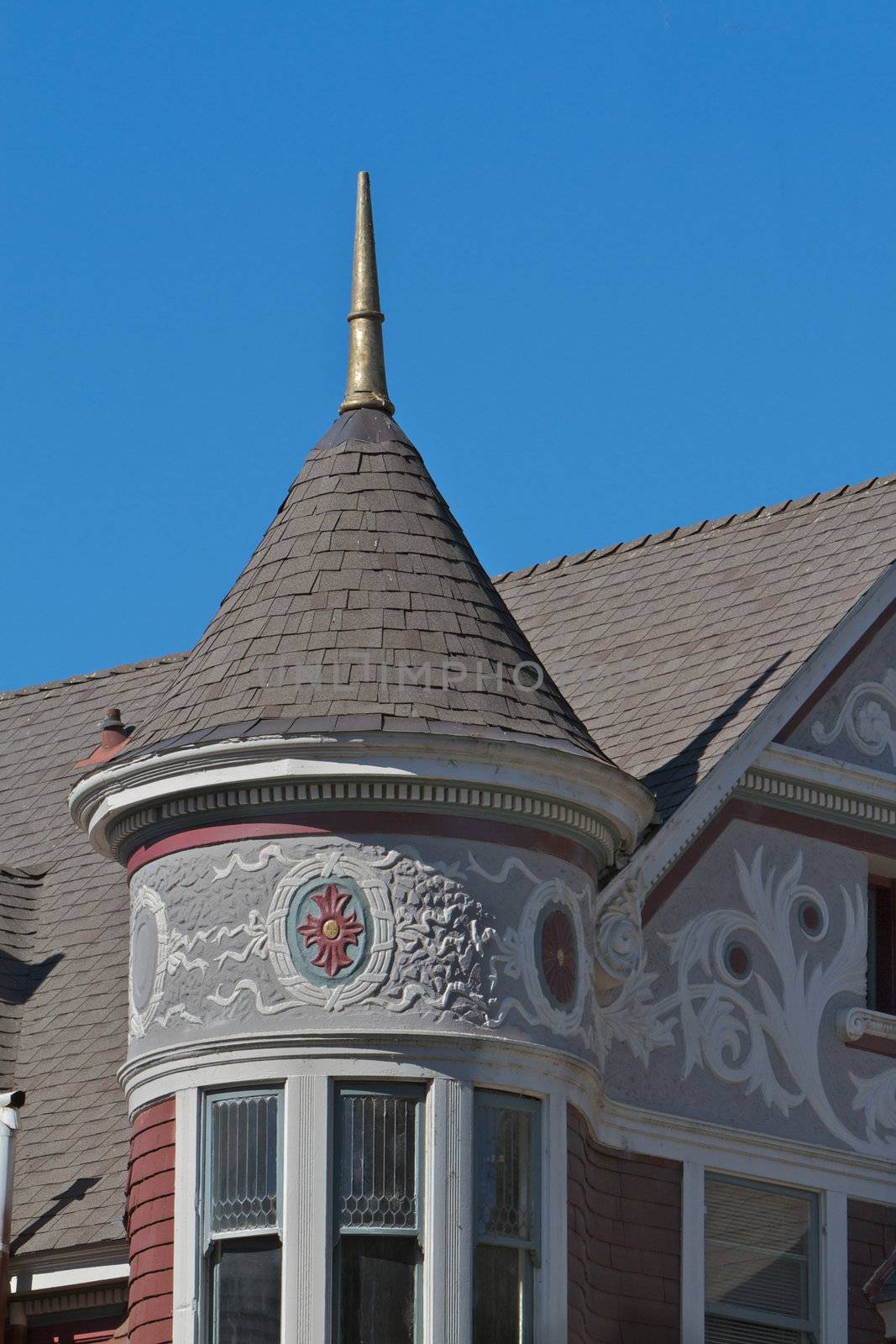 Tower with ornate woodwork on a victorian house with blue sky background