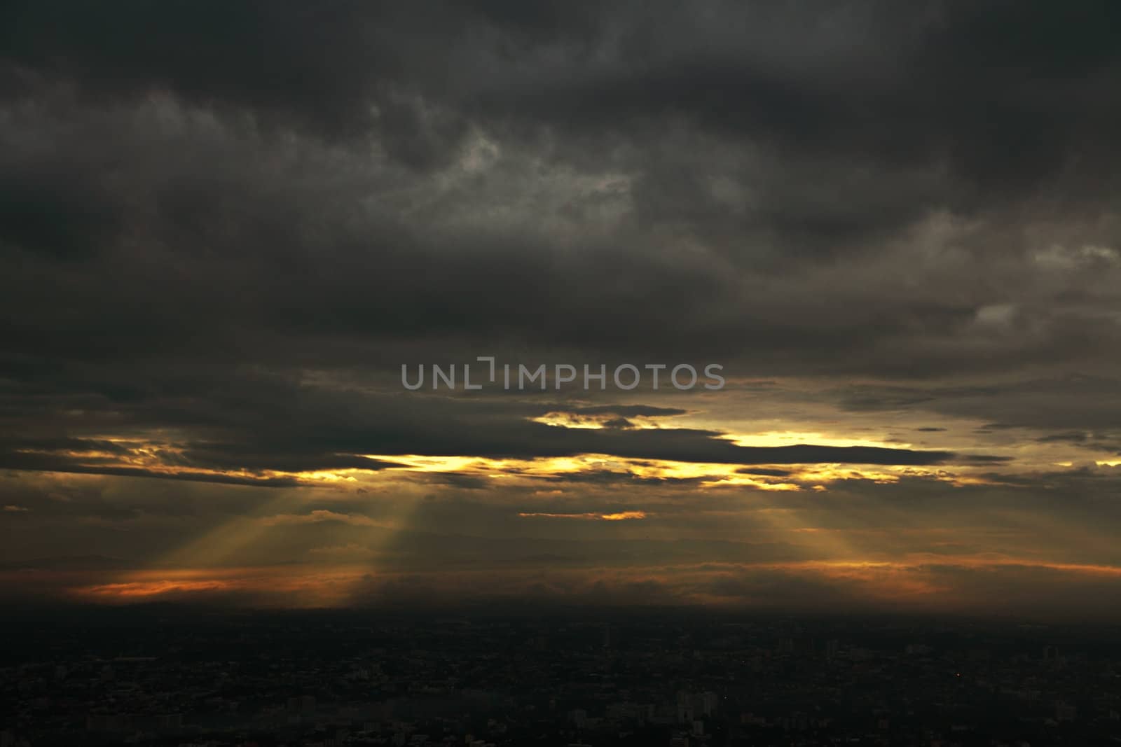 Sunbeams bursting through a dark cloudy sky