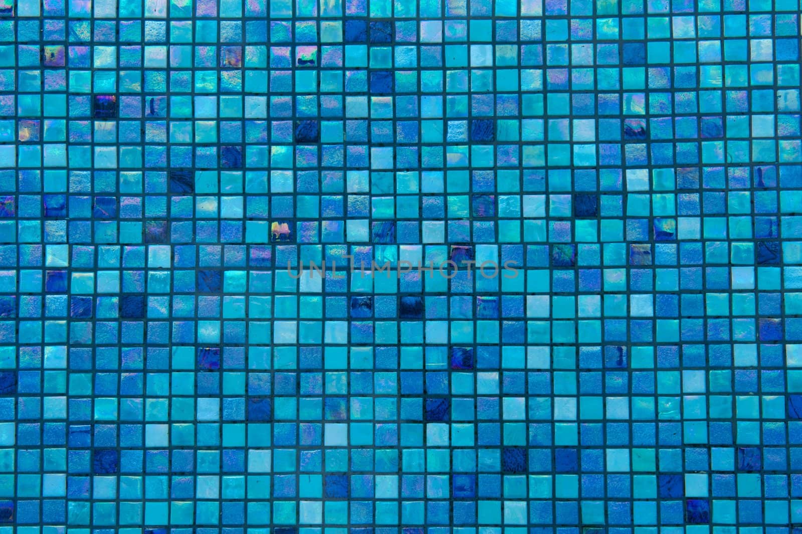 Bright blue glass tiles lining the bottom of a swimming pool