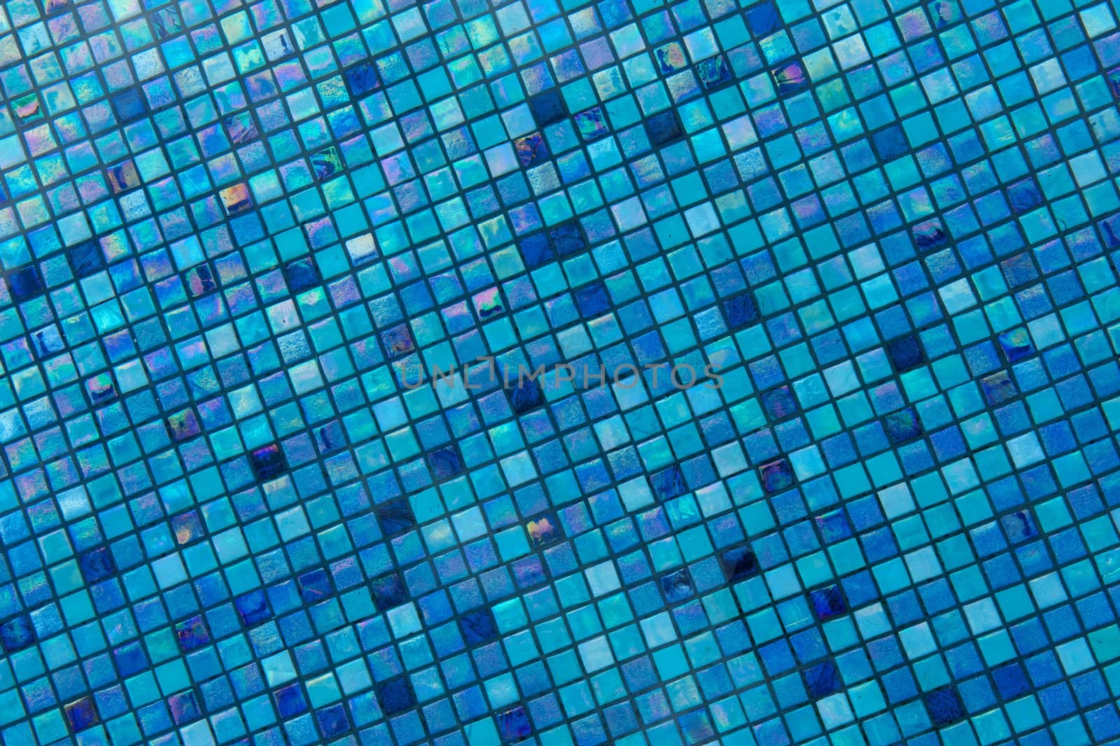 Bright blue glass tiles lining the bottom of a swimming pool