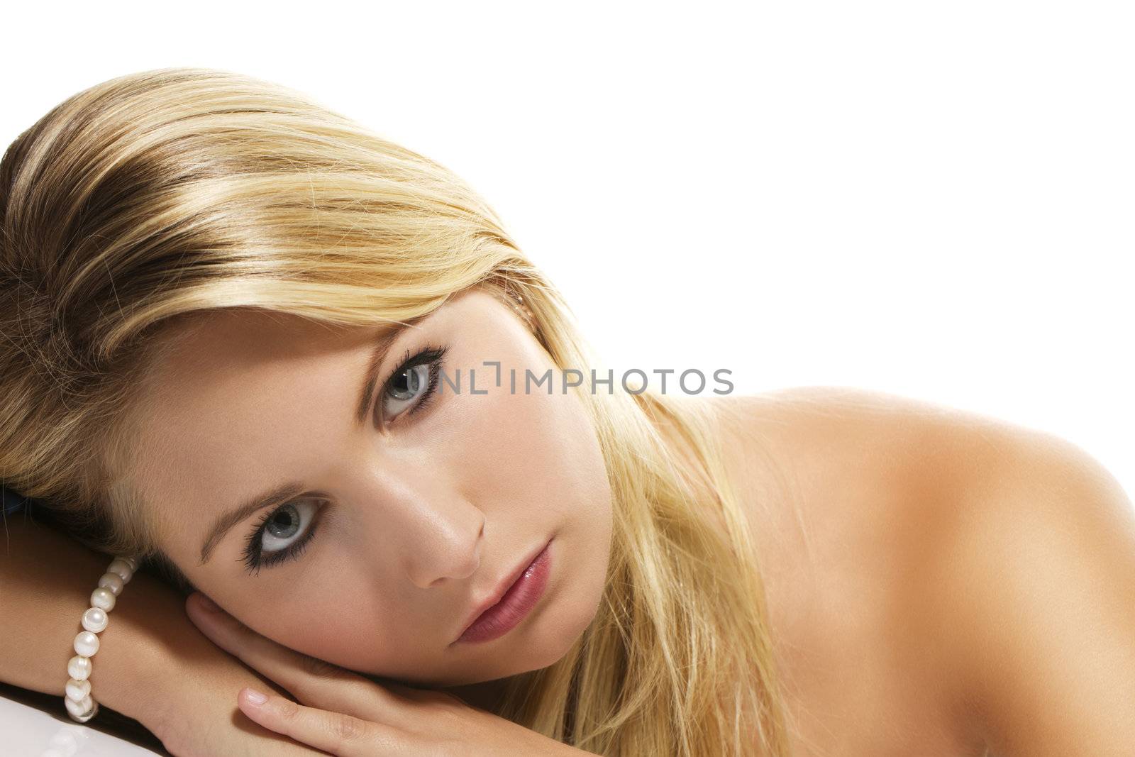 beautiful blonde woman laying her head on a table on white background
