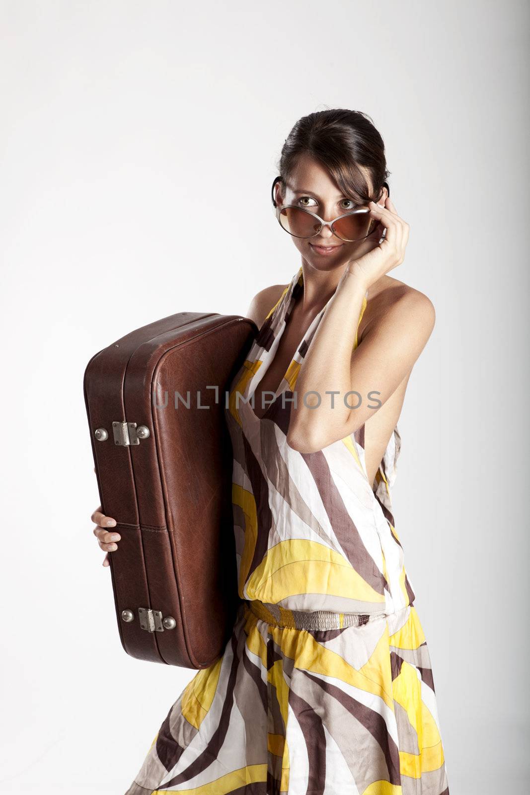 Beautiful fashion woman posing with a vintage suitcase
