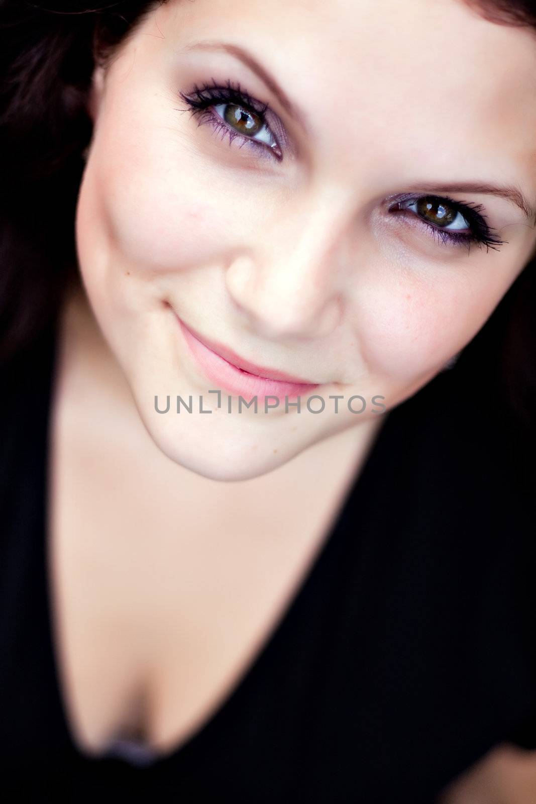 Close up of a beautiful young woman in a black dress.  Shallow depth of field.