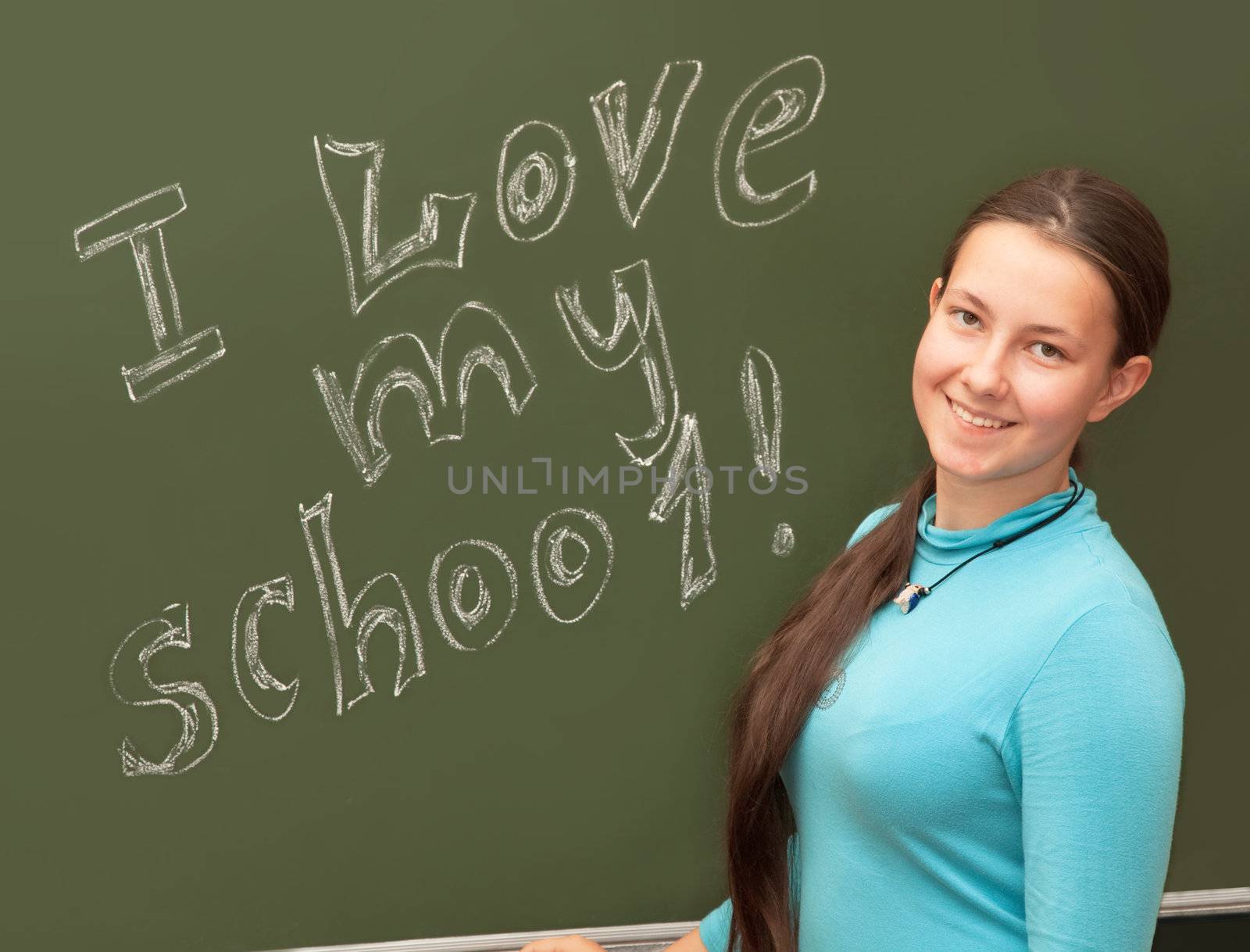 Girl schoolgirl meets an English lesson on the background of the school boards 