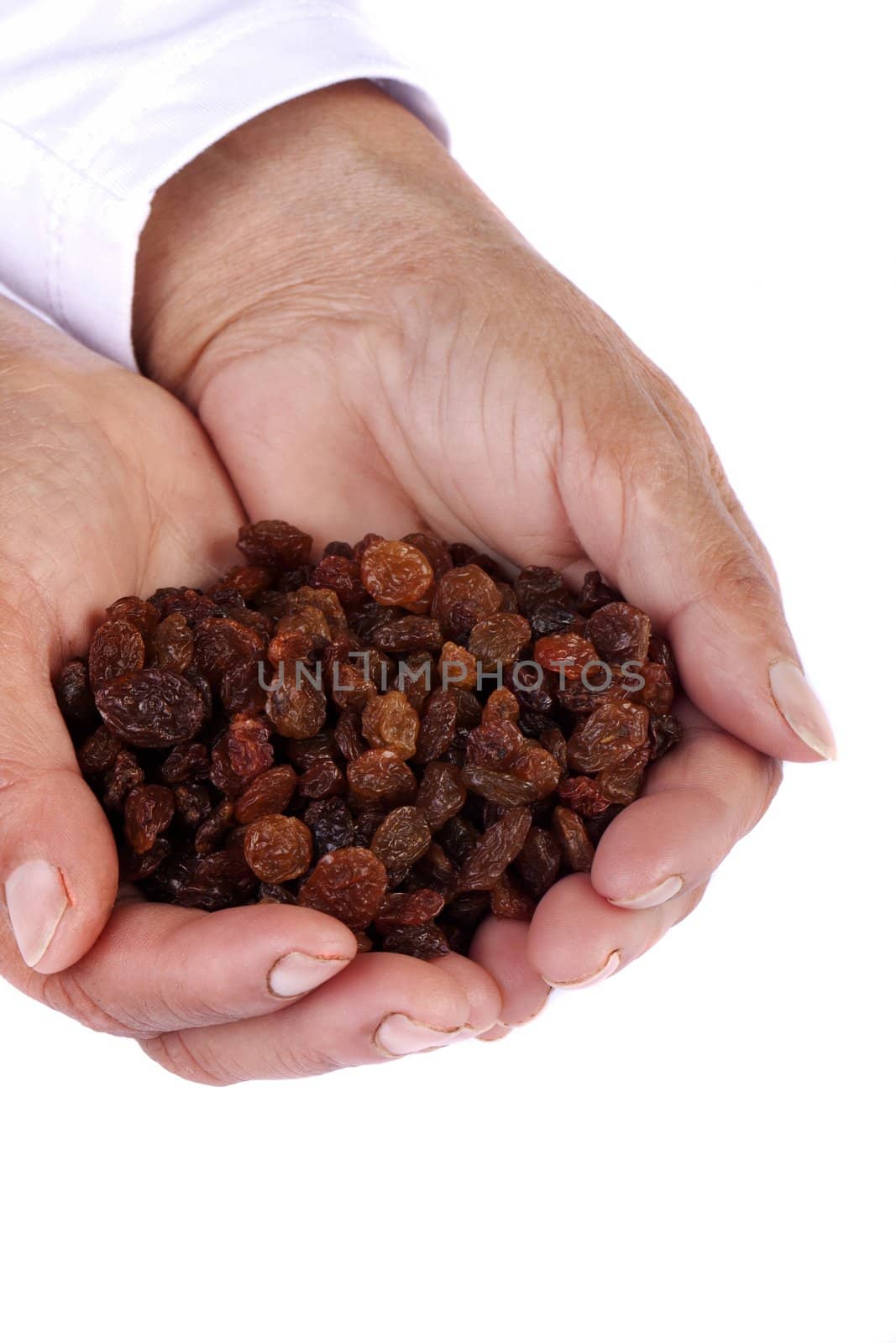 Close view of a pair of hands holding some raisins isolated on a white background.