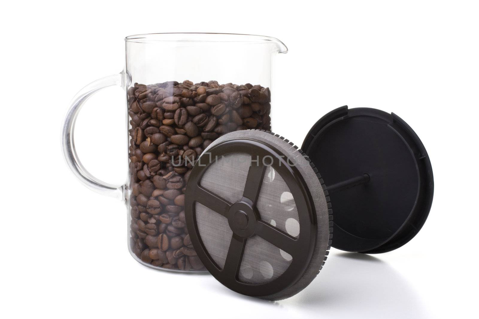 French press full of coffee beans, vertical orientation.