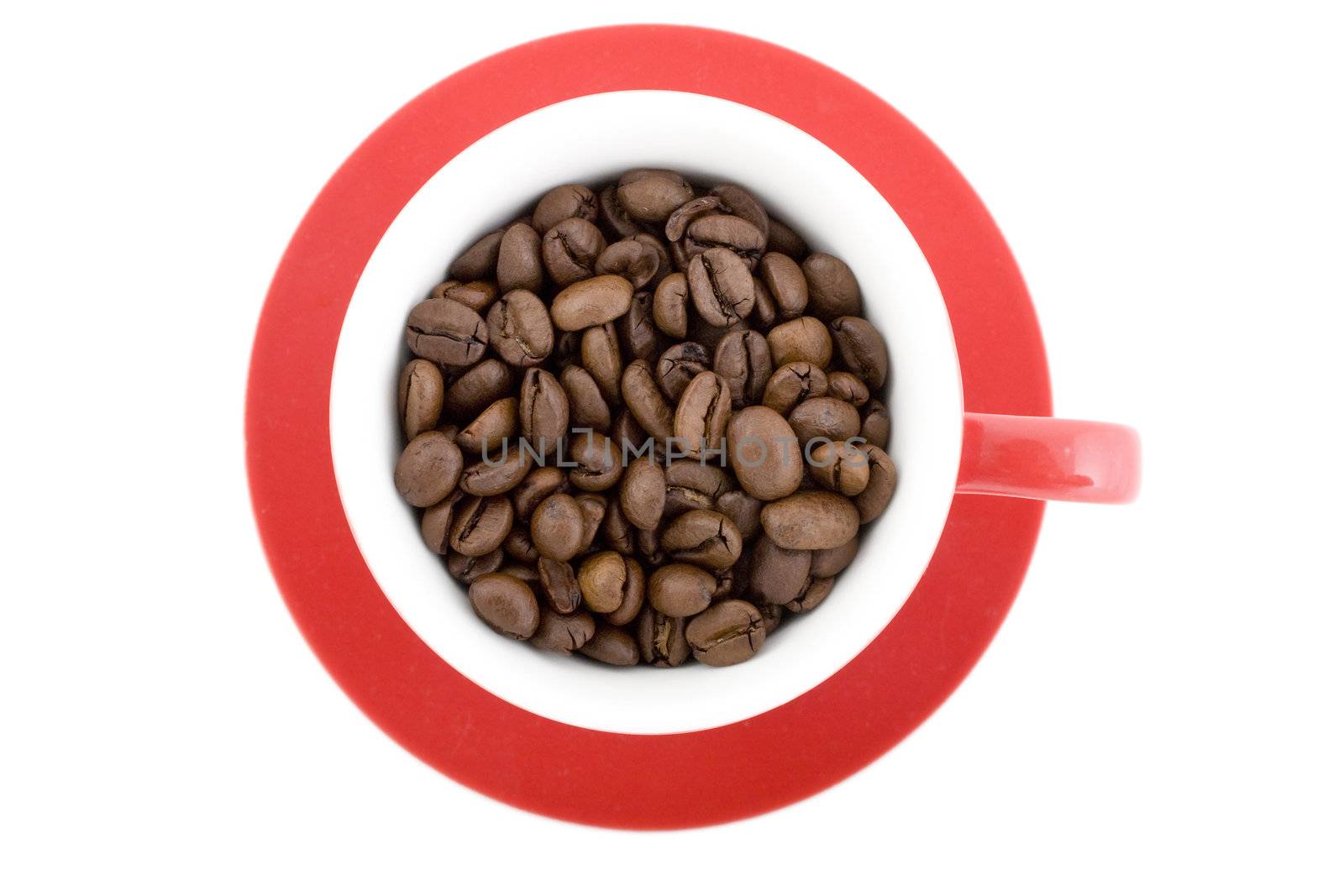 Red coffee cup with saucer full of coffee beans, photographed from directly above. 