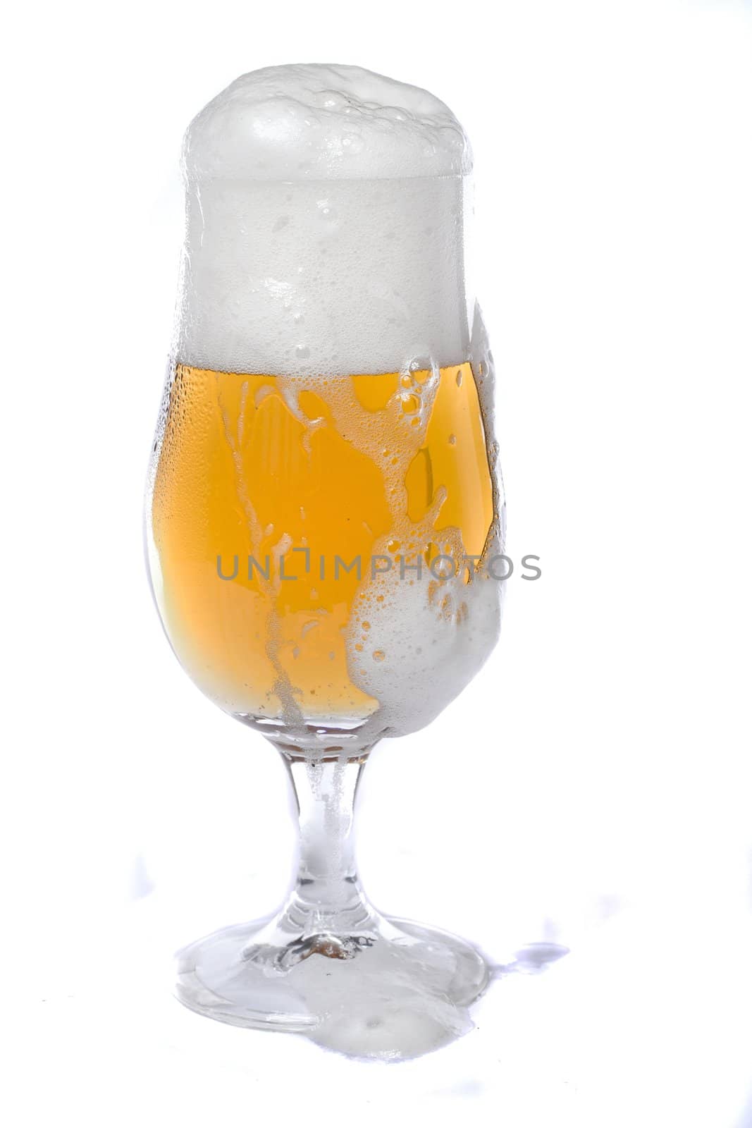 Close view of a glass of beer isolated on a white background.