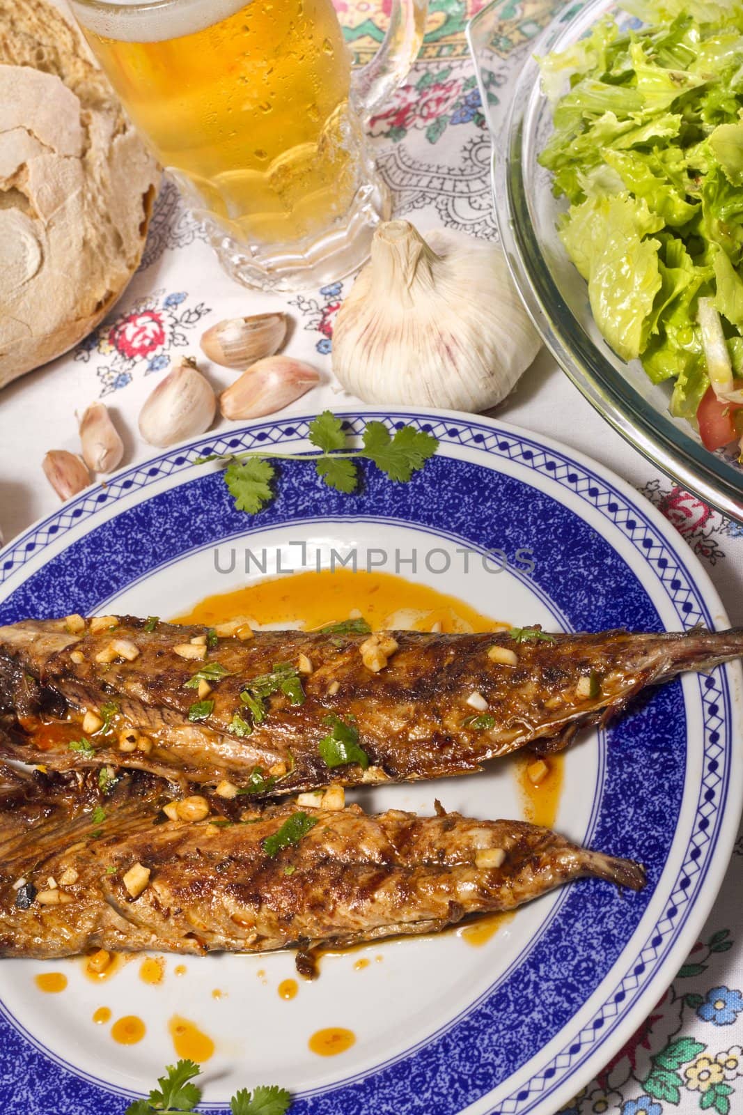 Close up view of a Portuguese meal of Wahoo grilled fish with annatto sauce and Mediterranean salad.  
