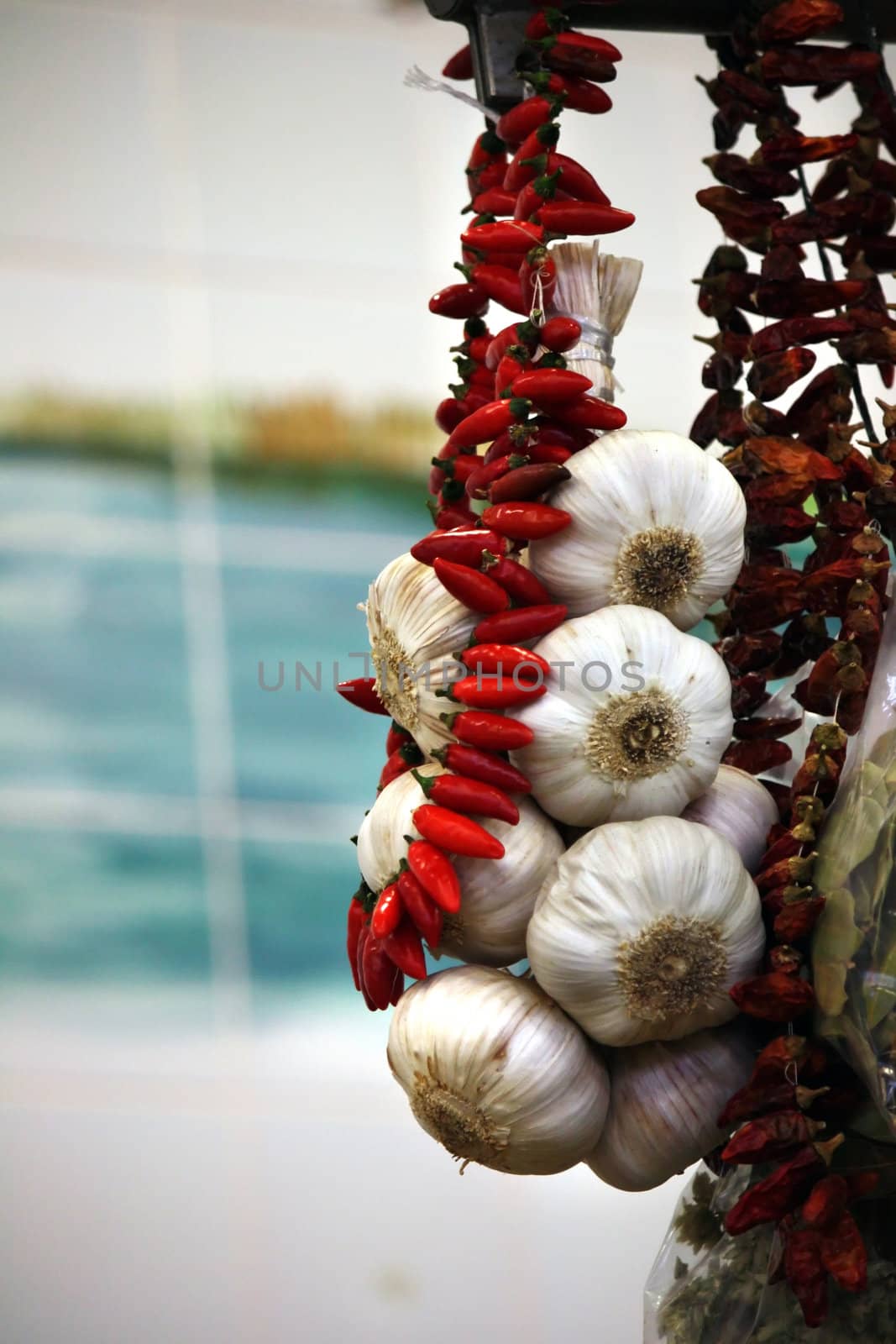 View on the street market some hanging garlic and red pepper.