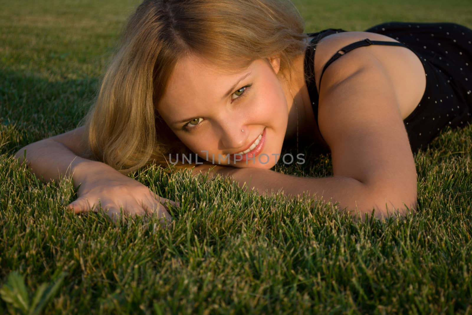 Portait of young pretty woman lying on grass