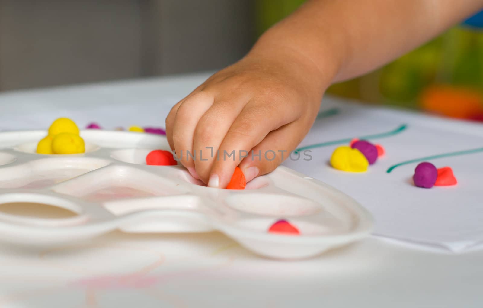 Baby hand and colored plasticine