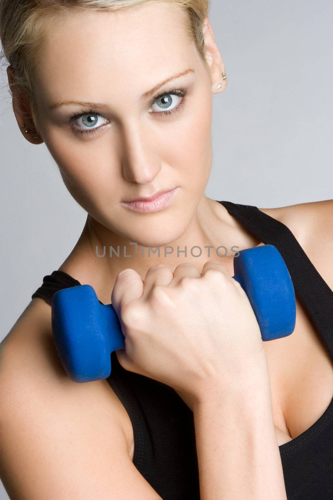 Beautiful fitness woman lifting weights