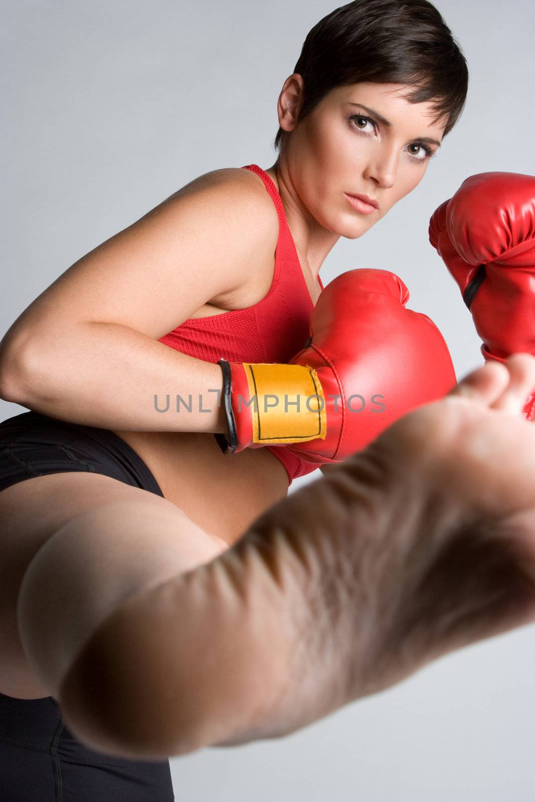 Beautiful athletic kickboxing woman kicking