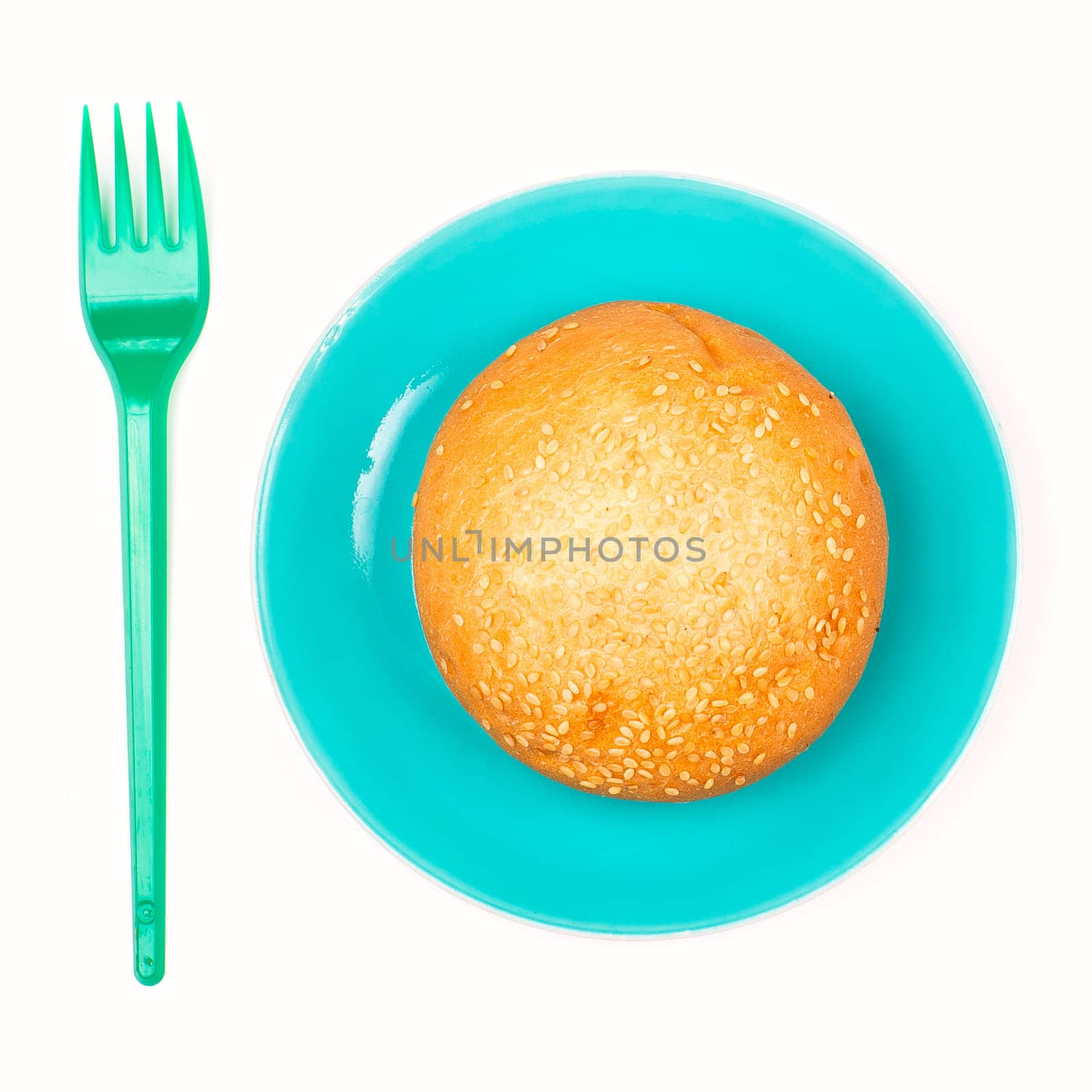 Bun on the plate and plastic fork isolated on the white background