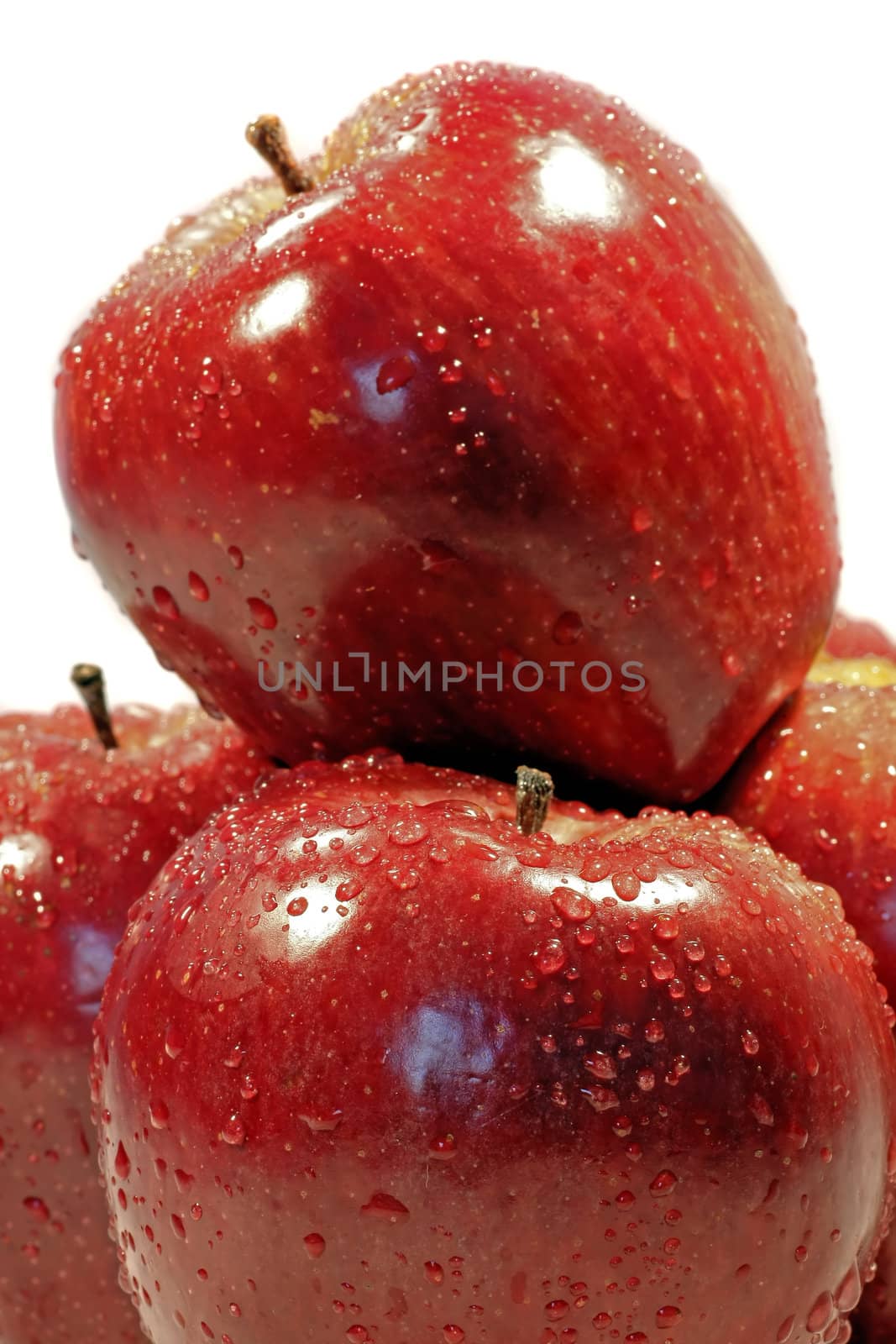 Pile of red apples with drops of water isolated on a white background.