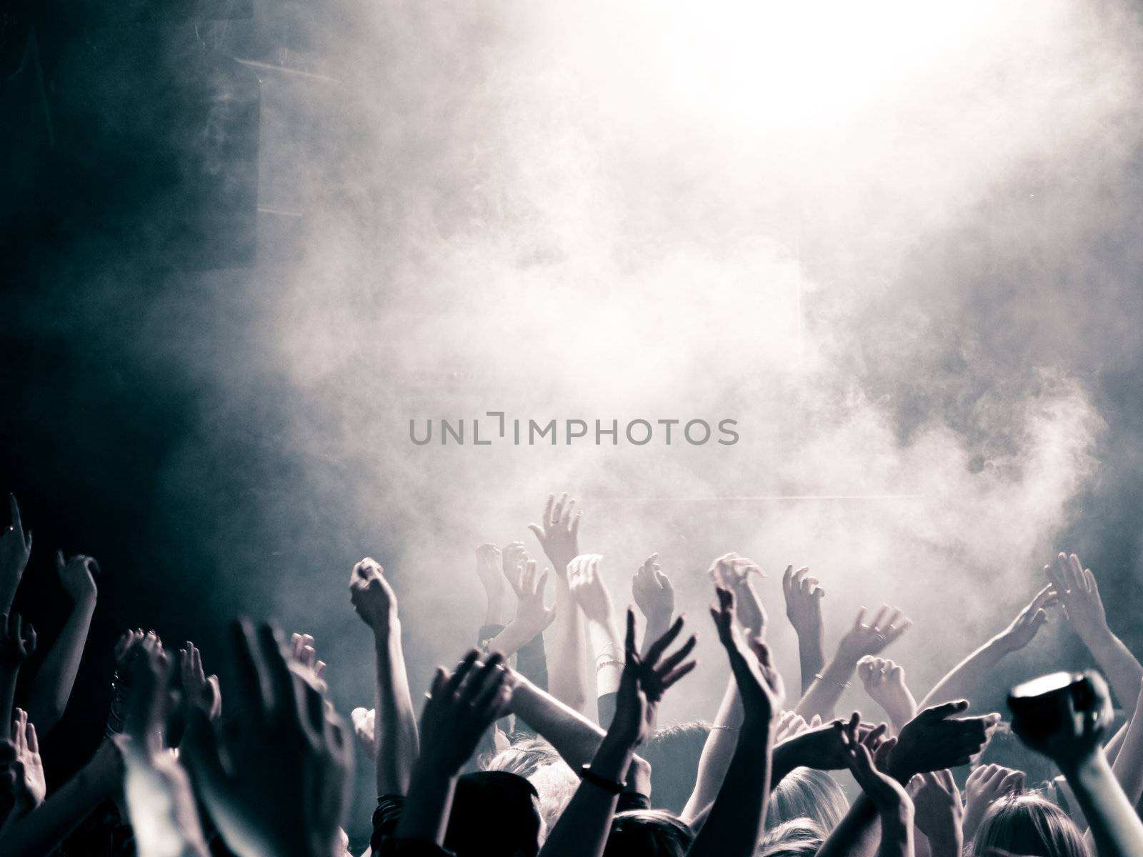 people at a concert, hands up