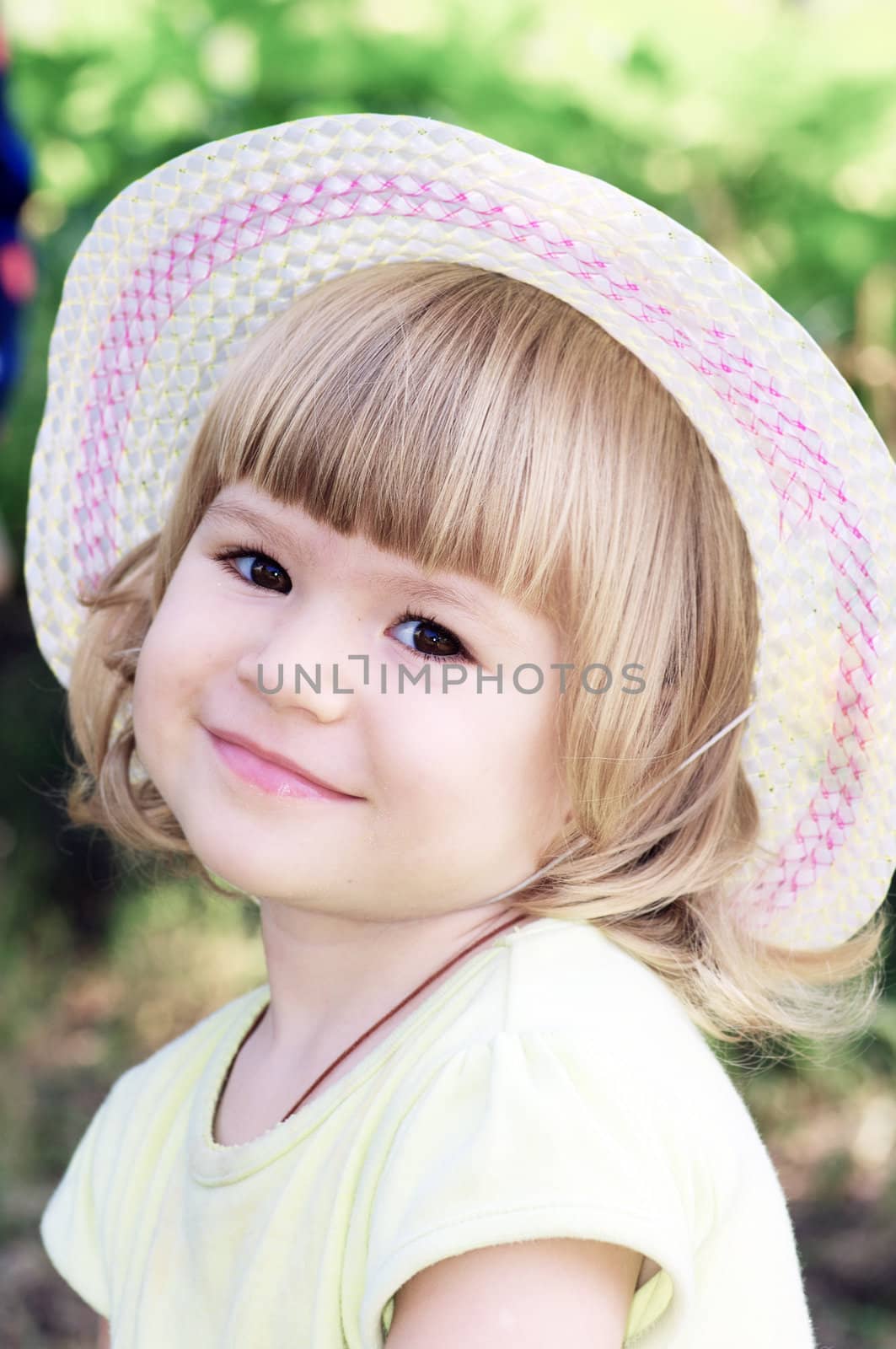 Smiling girl on the meadow looking right at camera 