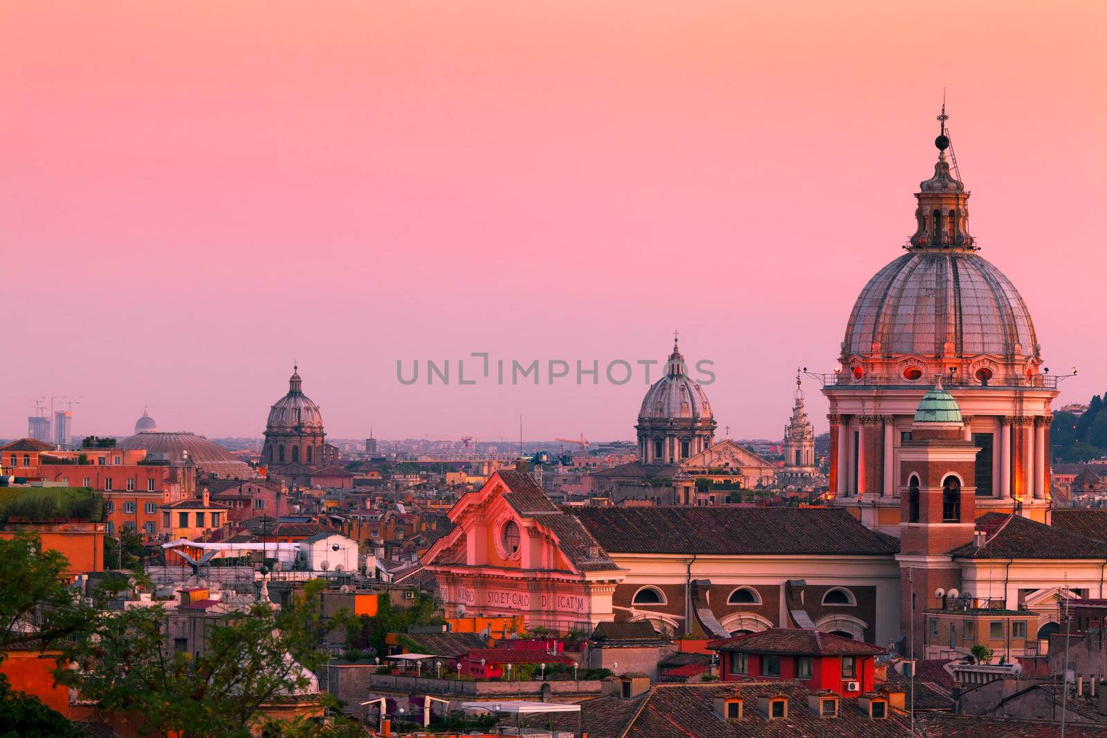 Rome skyline at dusk. In the foreground San Carlo al Corso Church.