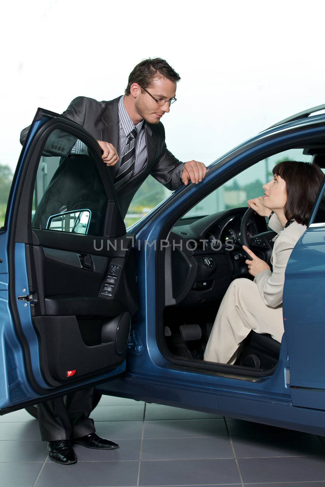 Car salesperson explaining car features to customer
