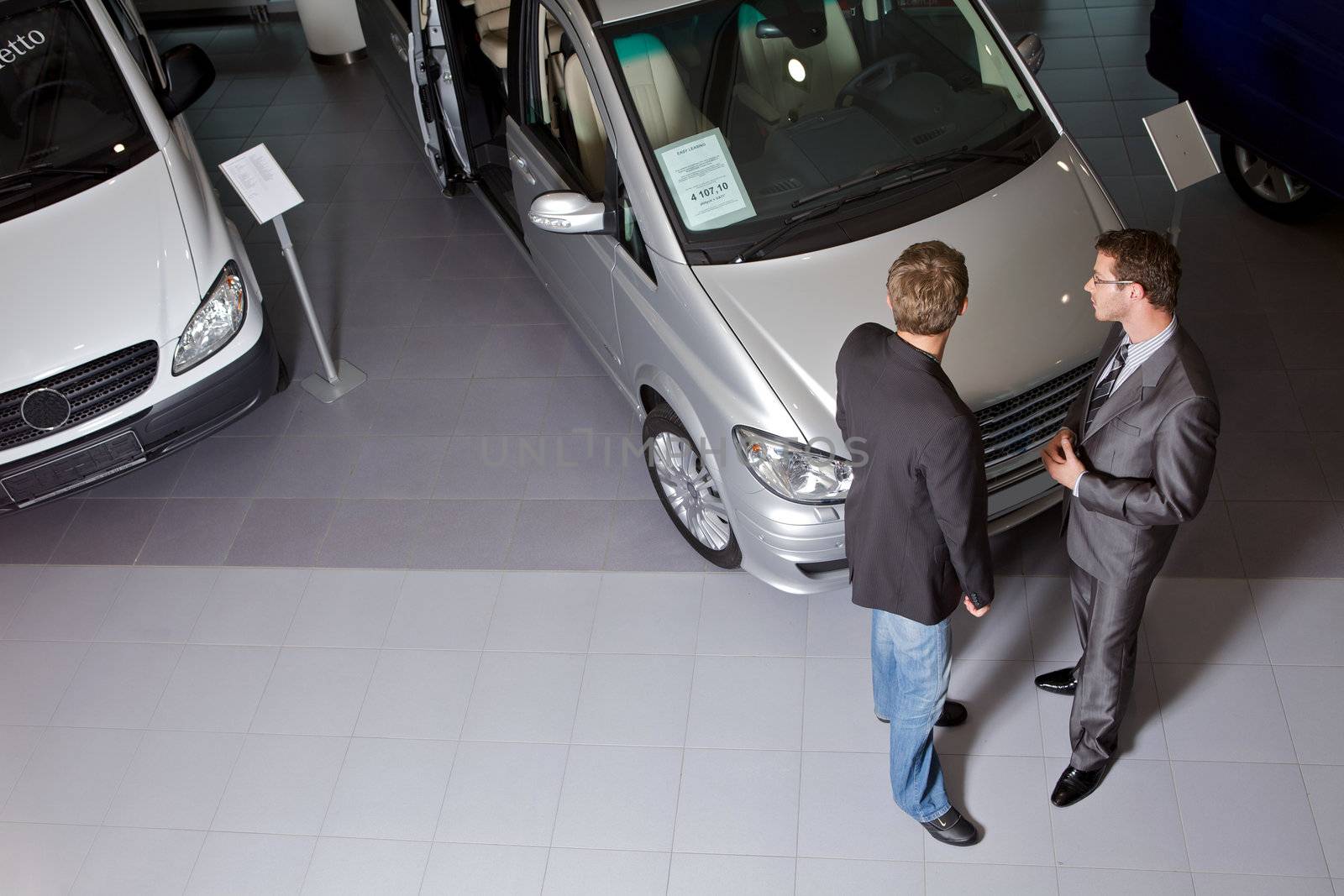 Car salesperson explaining car features to customer
