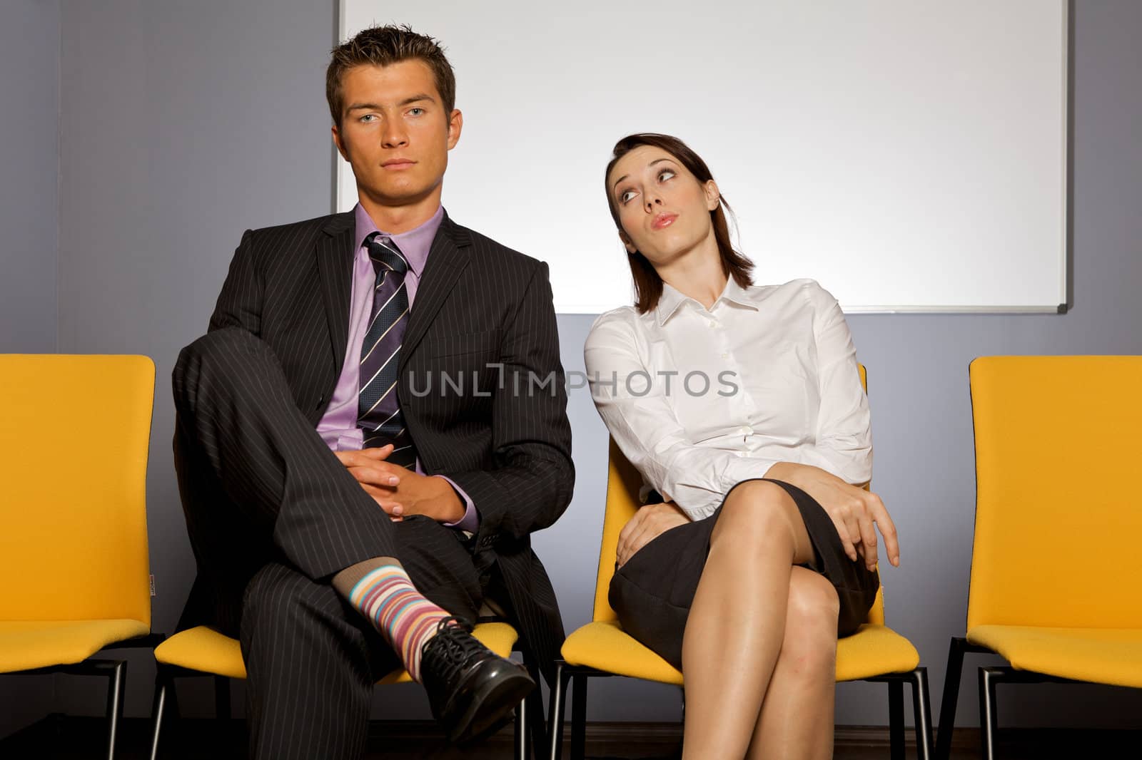 Businessman and businesswoman sitting in waiting room