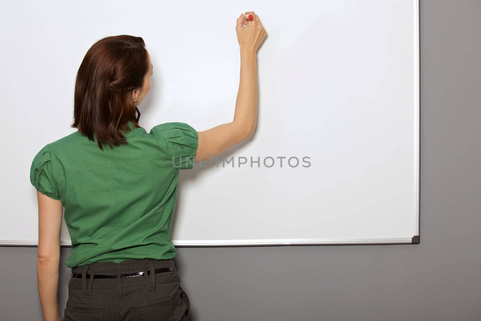 Businesswoman writing on whiteboard in office