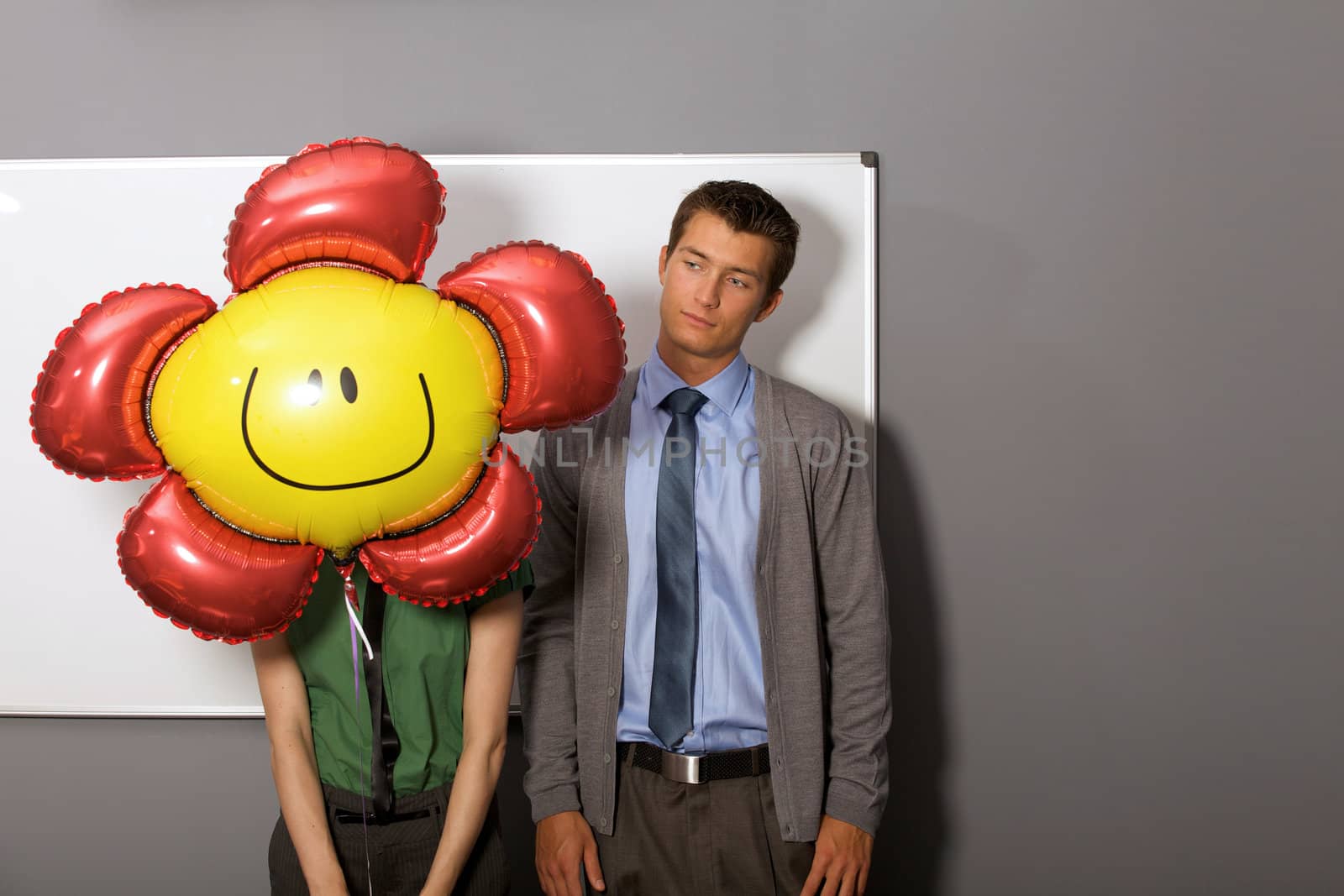 Businessman looking at balloon over woman's face