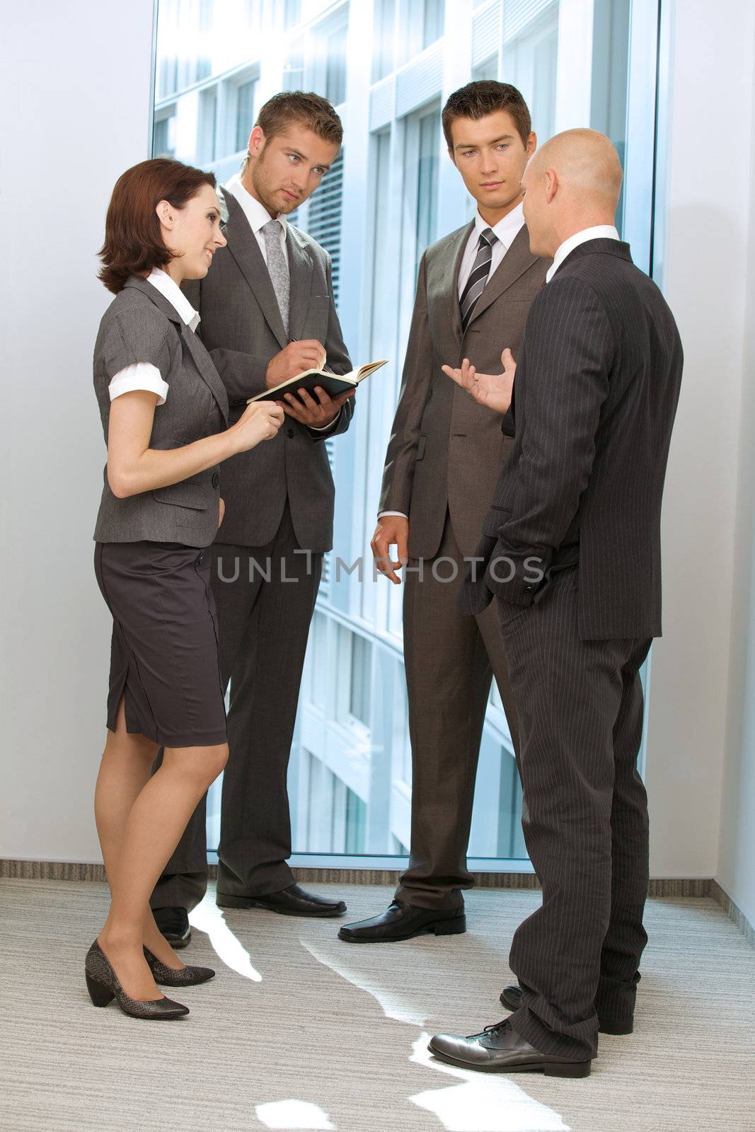 Portrait of young caucasian business people talking in office