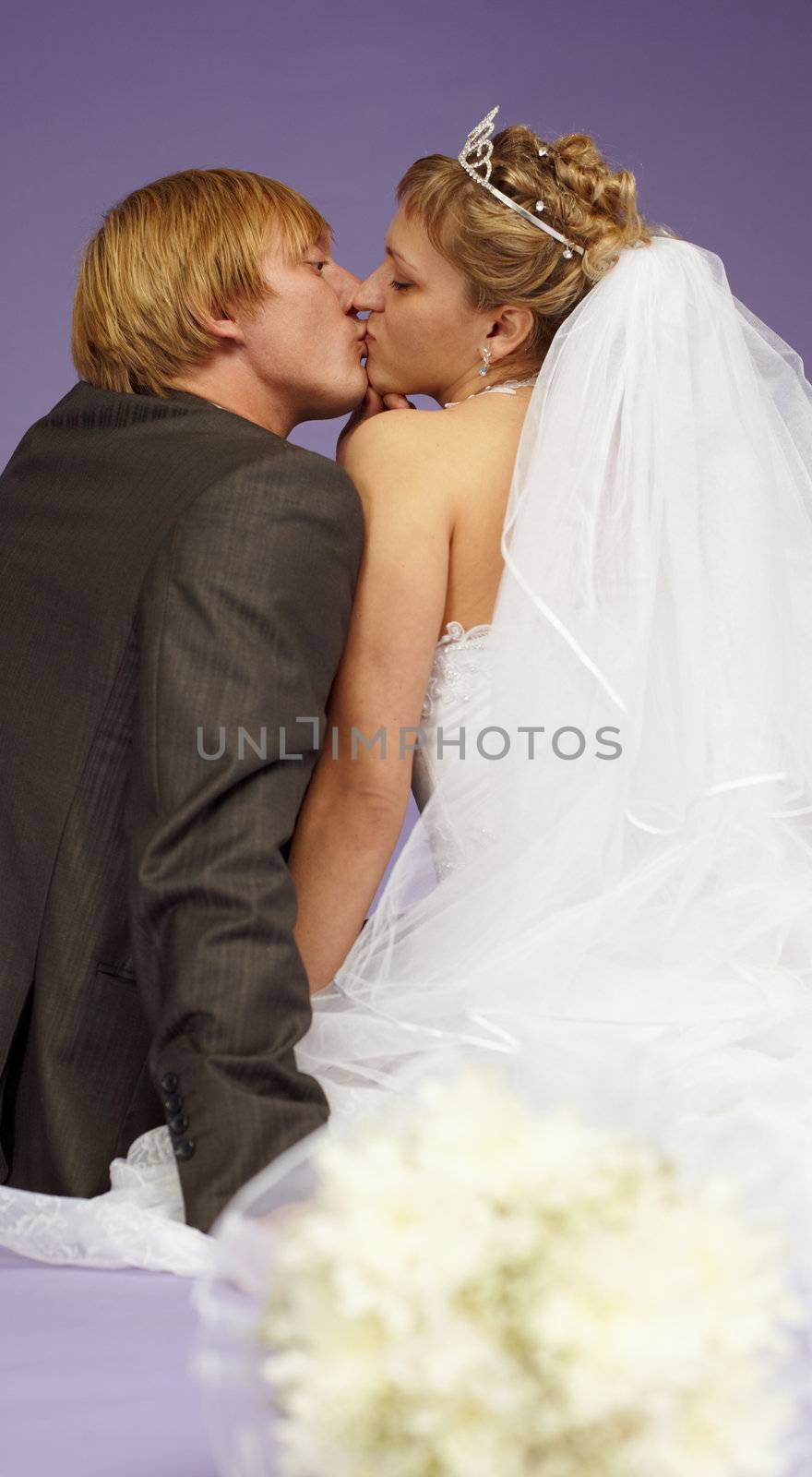 Kissing newlyweds on a purple background