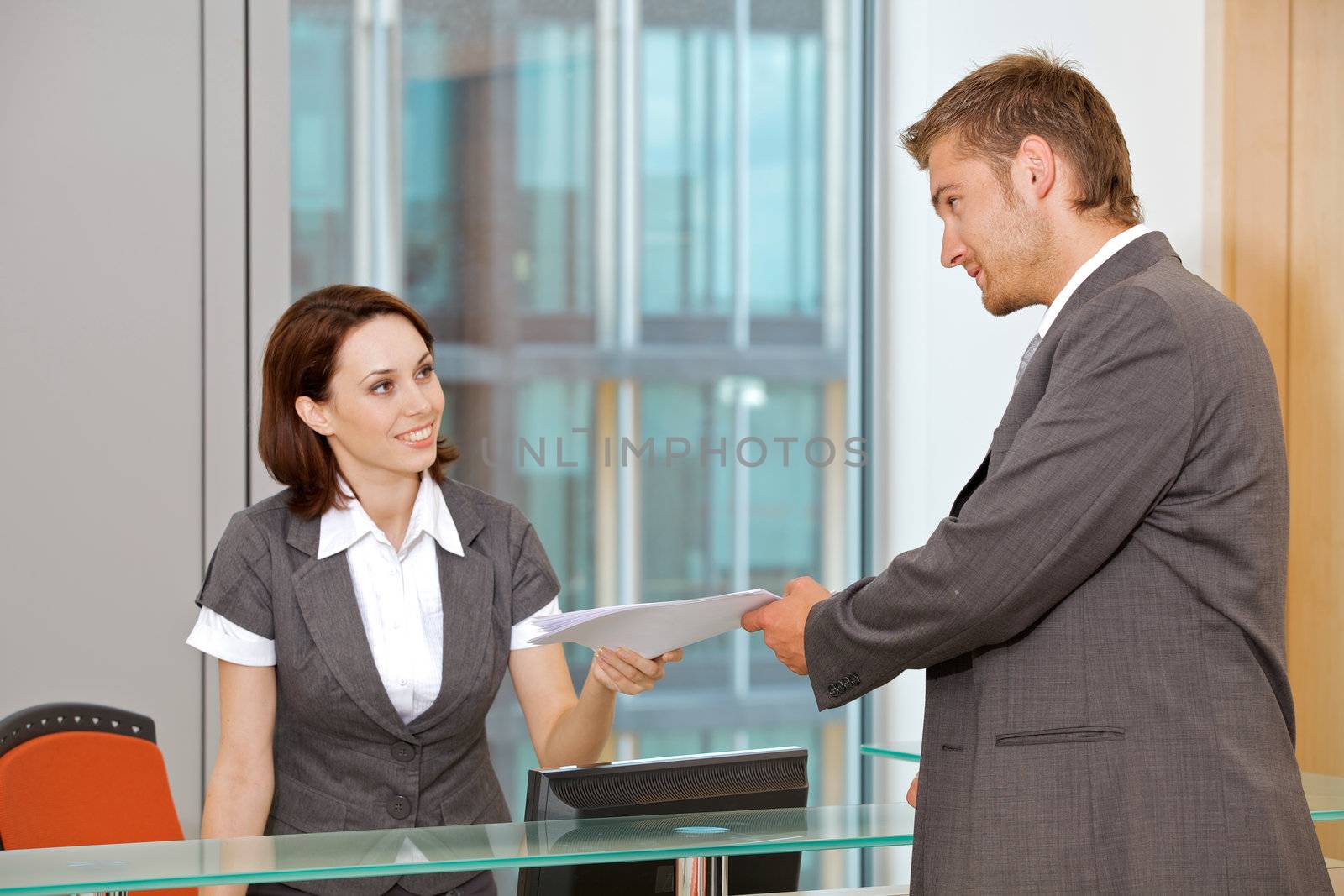 Young caucassian secretary assisting businessman