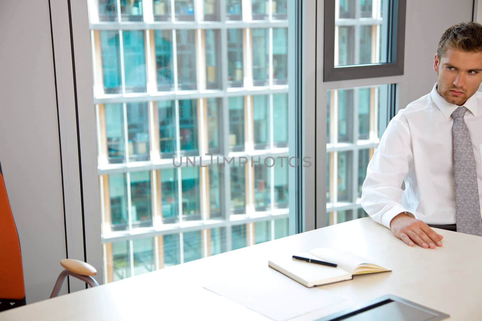 Young confident caucasian businessman sitting at the office desk