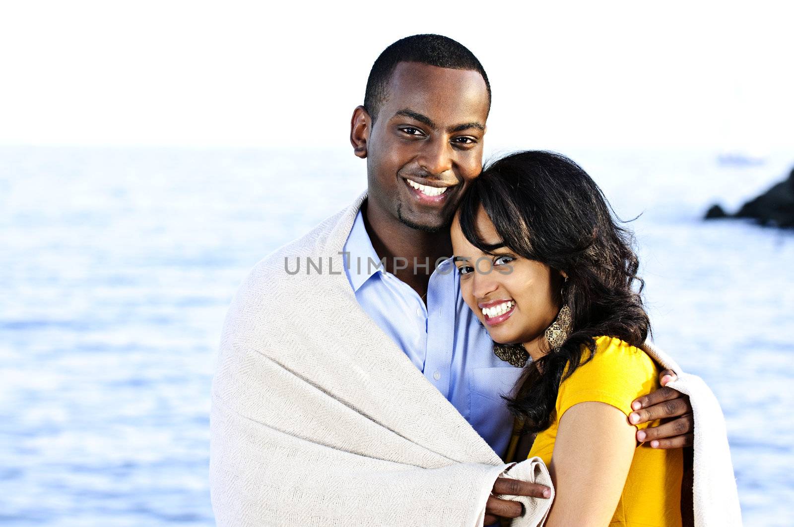 Happy couple sharing blanket by elenathewise