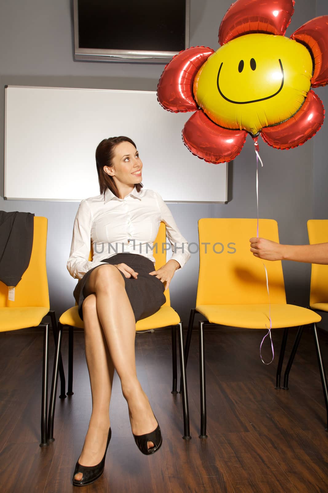 Businesswoman looking at balloon in waiting room