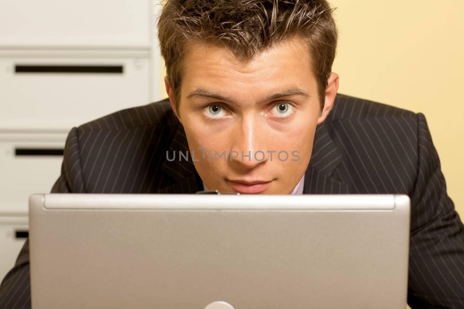 Portrait of businessman with laptop at office