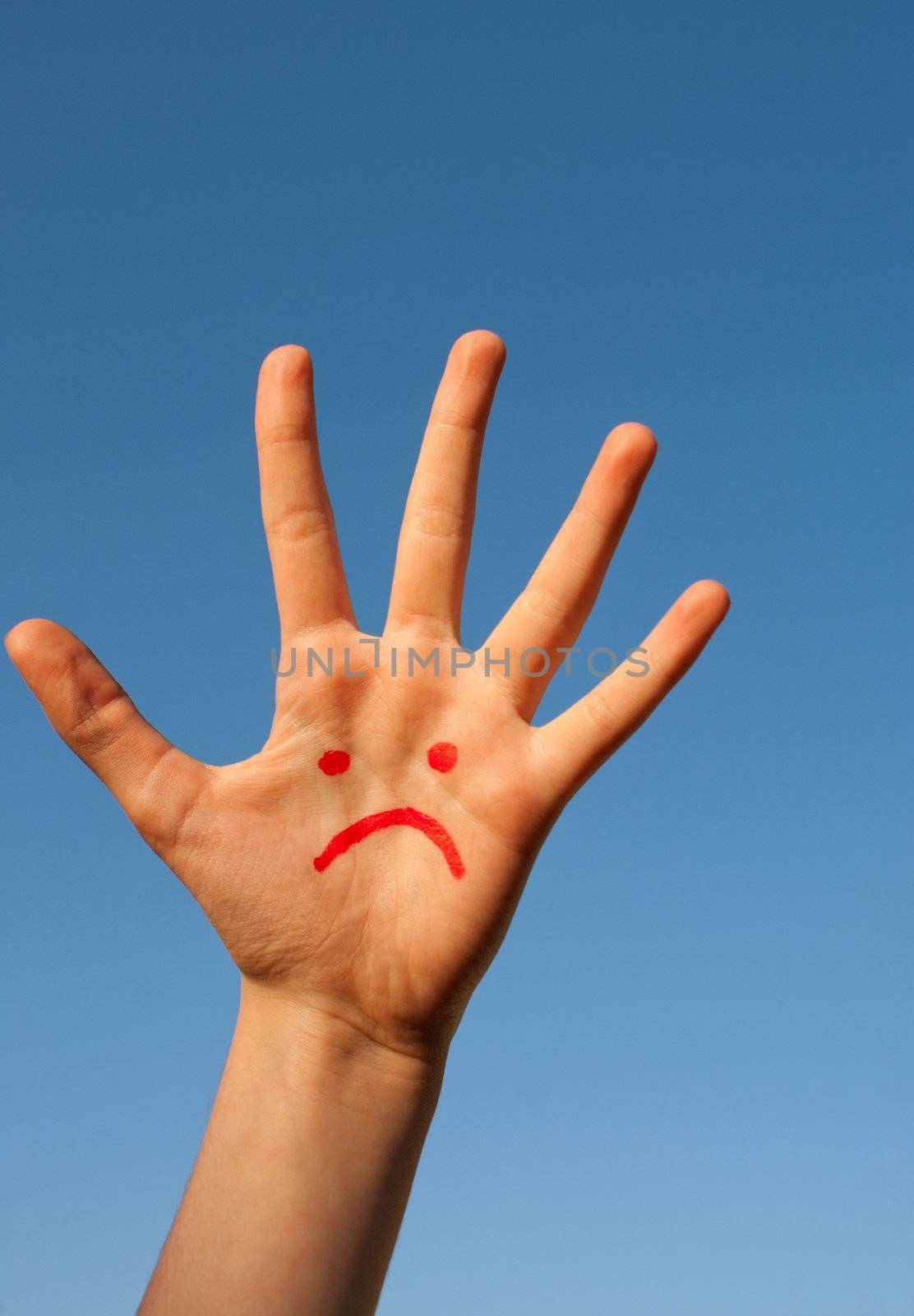Human's palm with unhappy smiley drawn on it