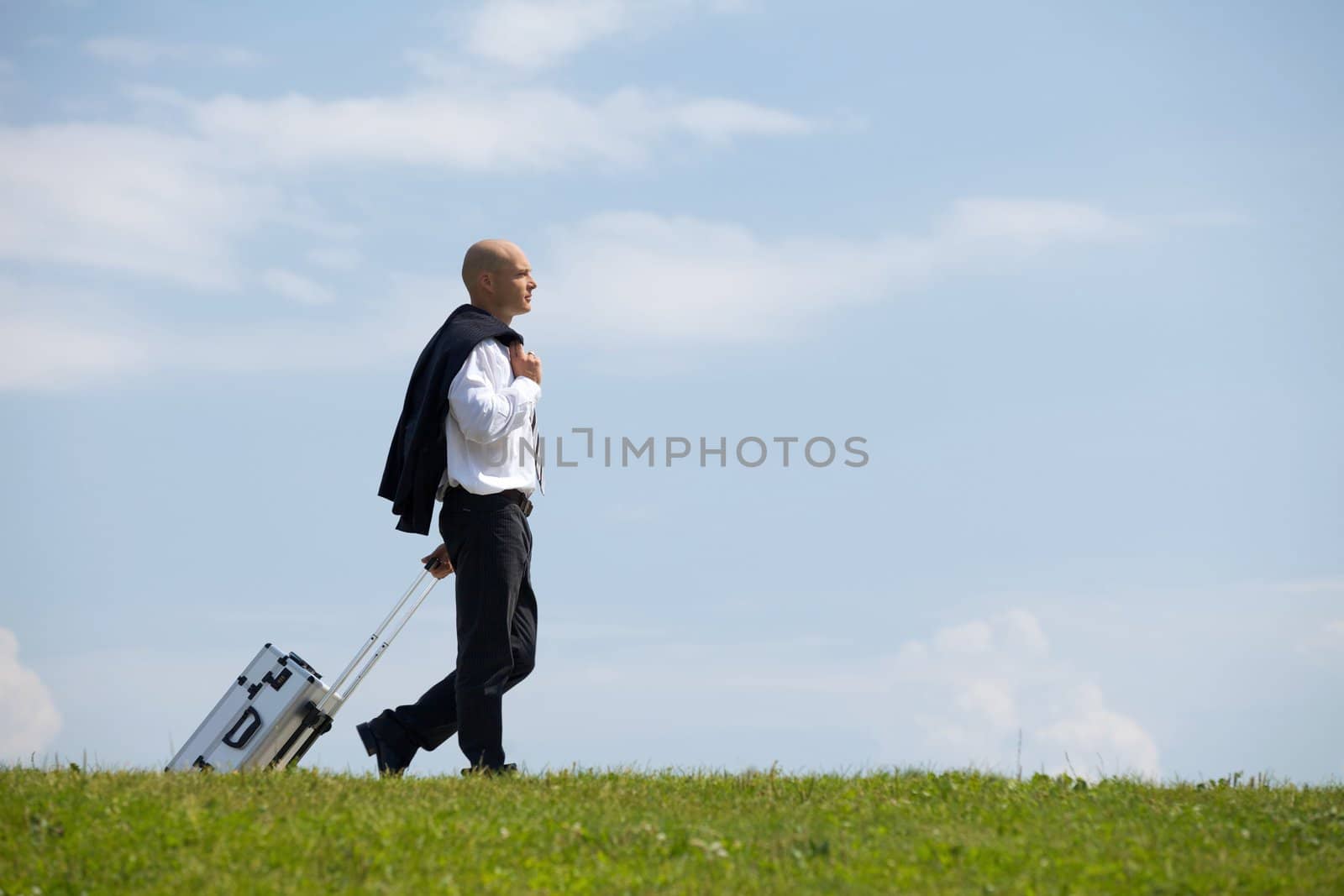 Businessman carrying luggage in park