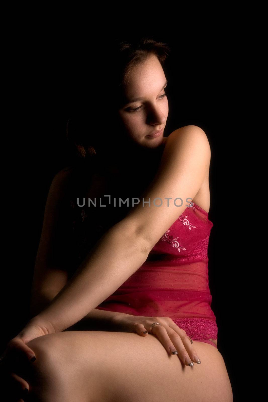 Studio portrait of a woman in luxurious lingerie in a low key setting