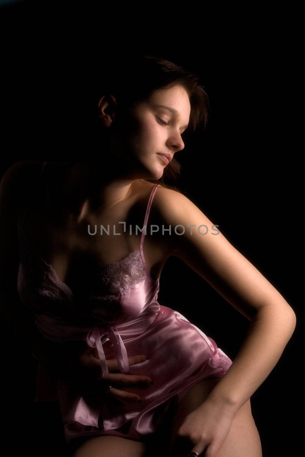 Studio portrait of a woman in luxurious lingerie in a low key setting