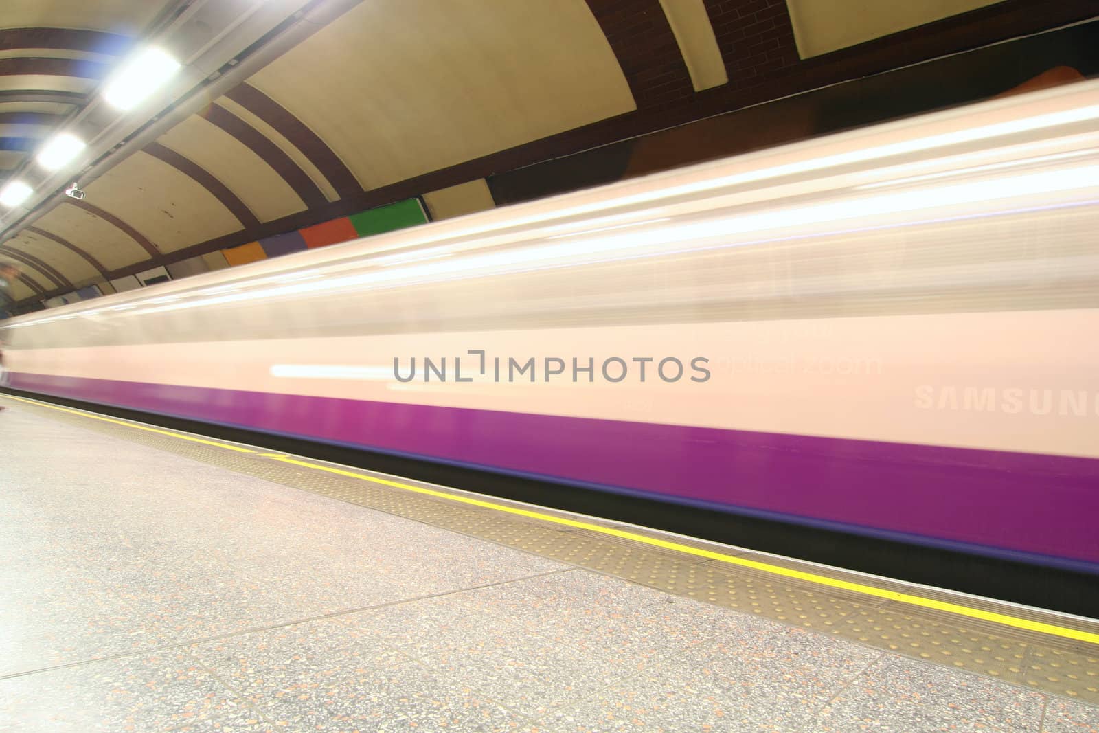 London subway station with train speeding past