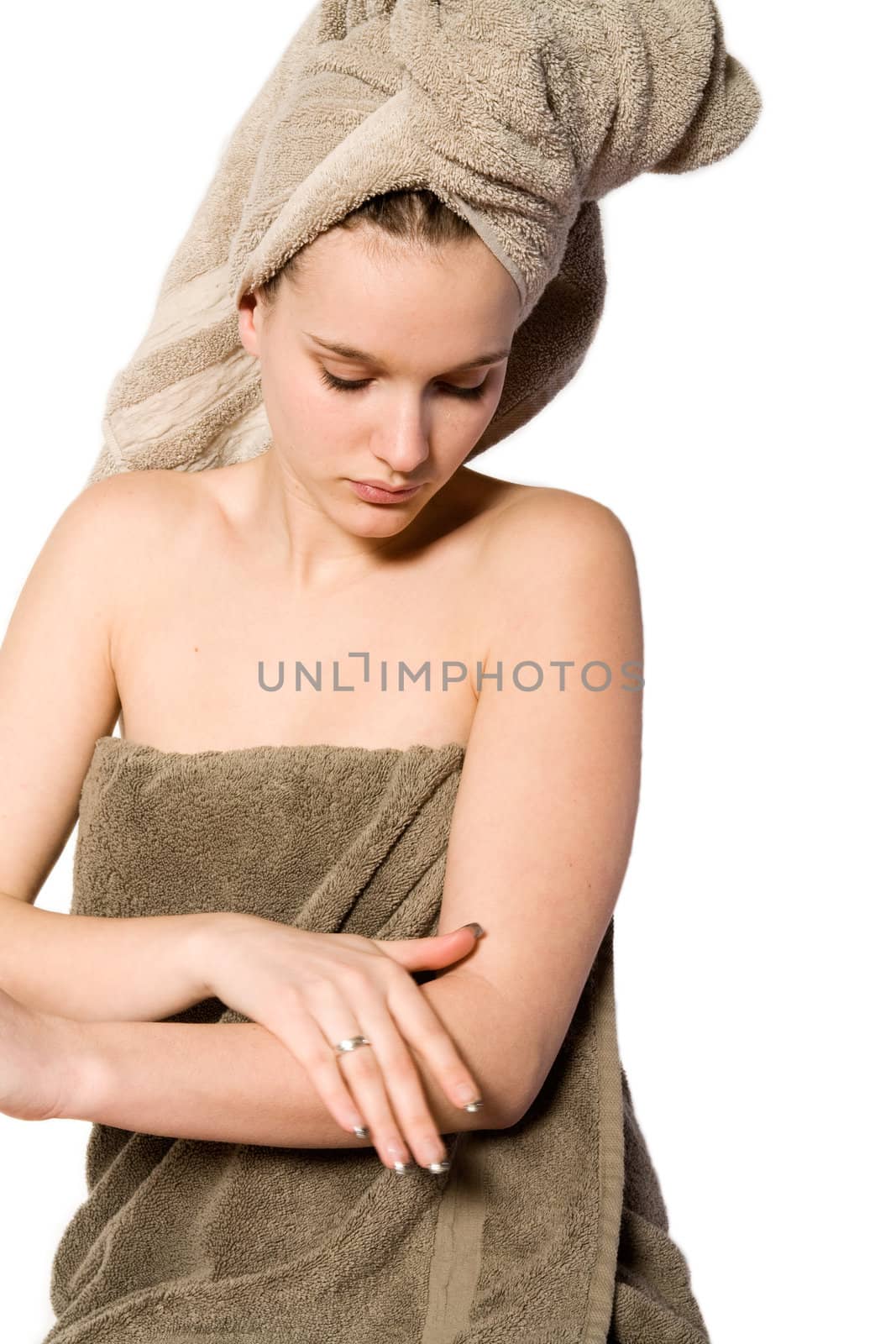 Young woman in towel on a white background applying creme