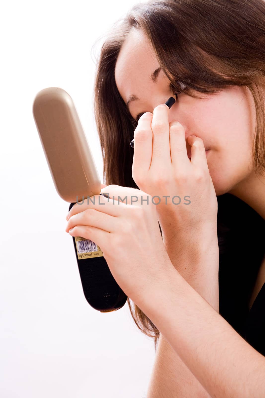 Cosmetic girl is completing her make up in the studio