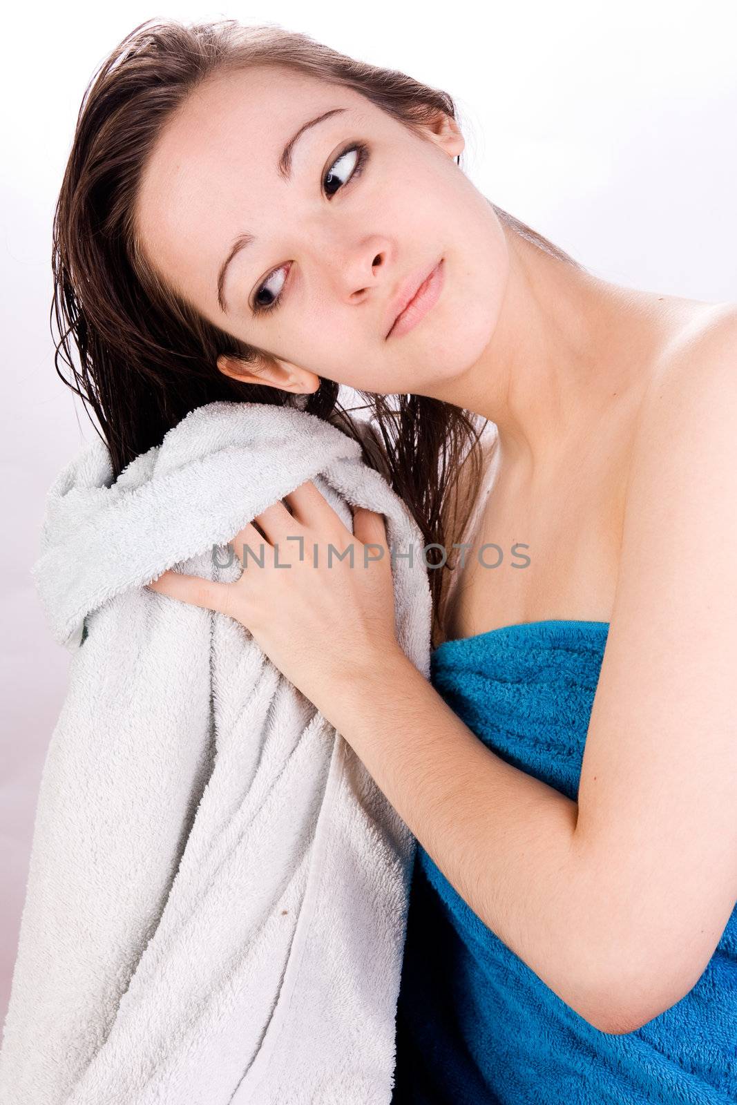 Young woman is drying her hair with a towel