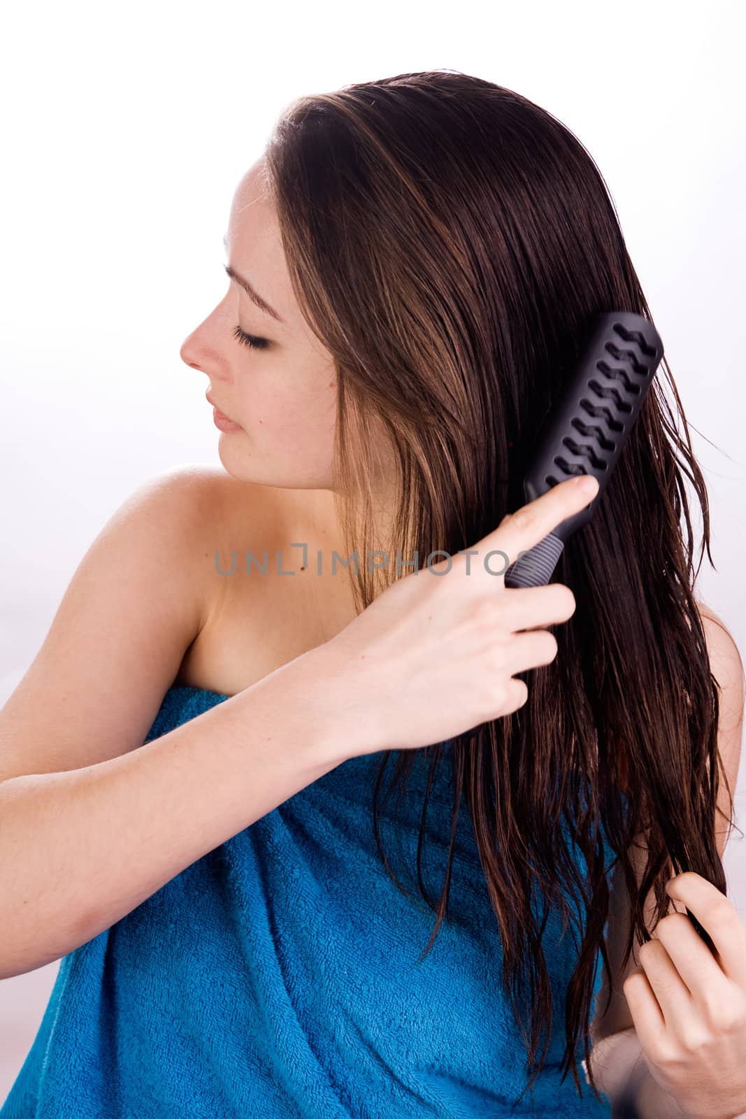 Woman is brushing her hair in the studio