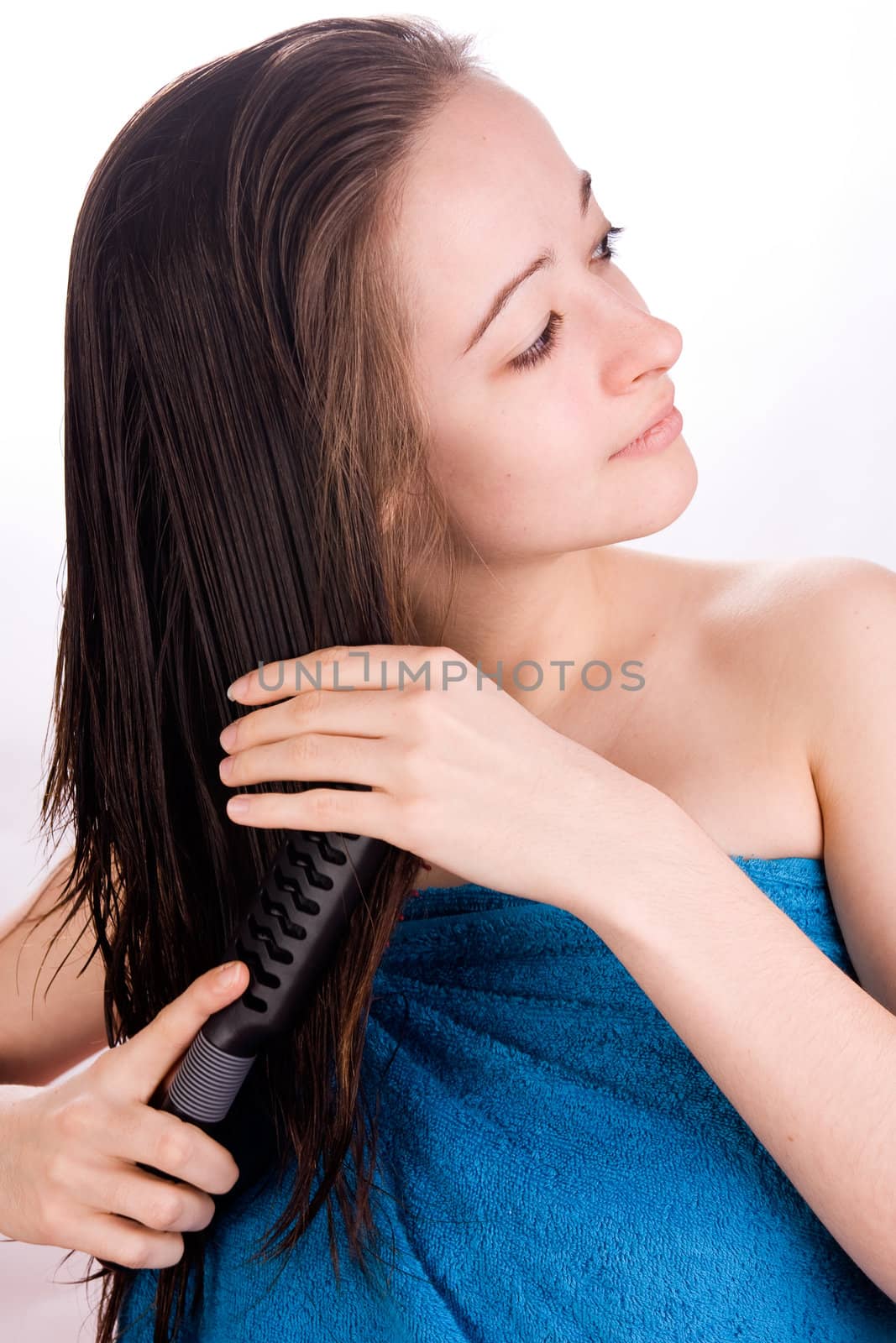 Woman is brushing her hair in the studio