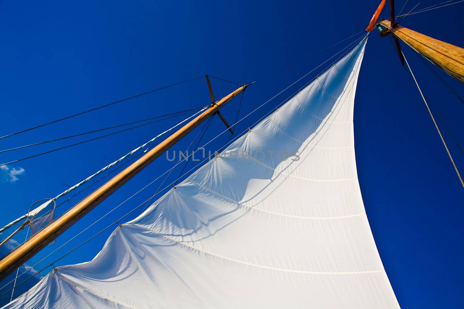 Yacht sail and blue cloudless aky above