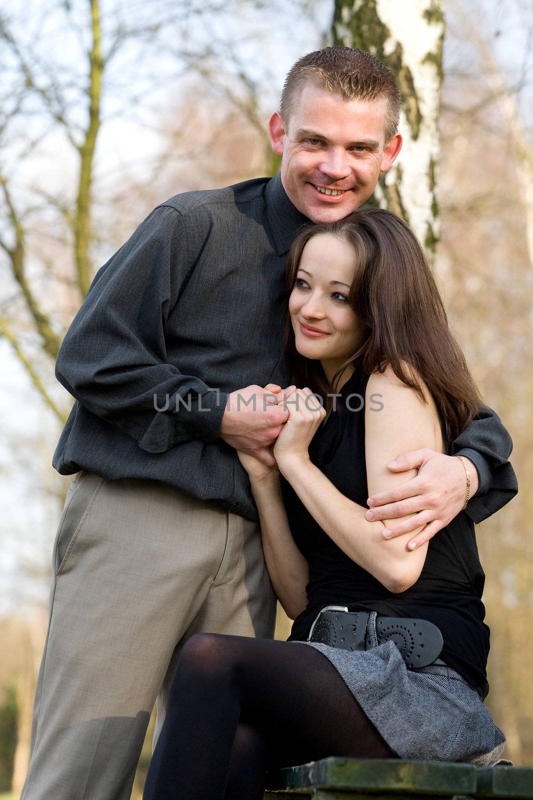 Man and girlfriend on a bench in a park caring