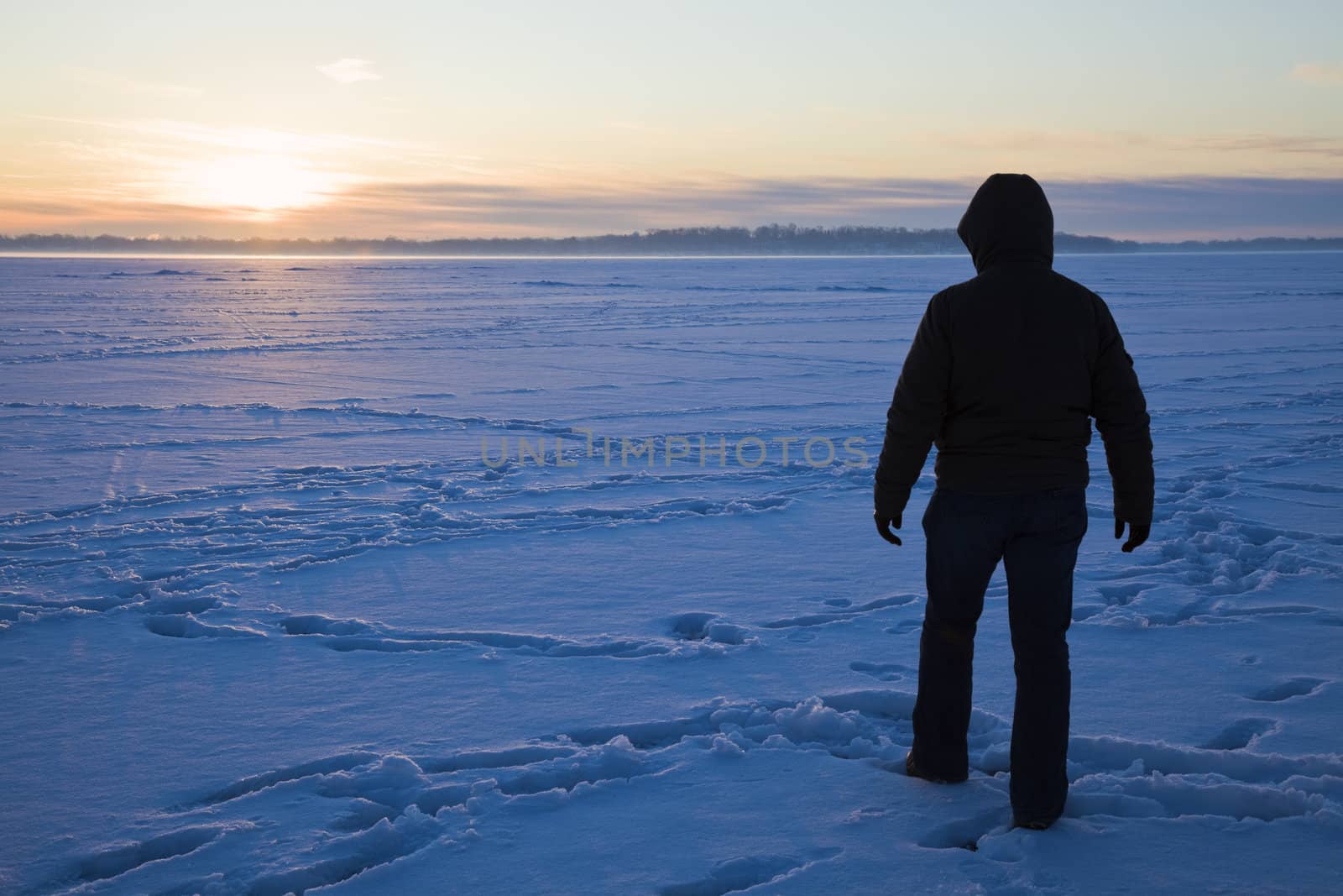 Silhouette of a fisherman walking on the lake by benkrut