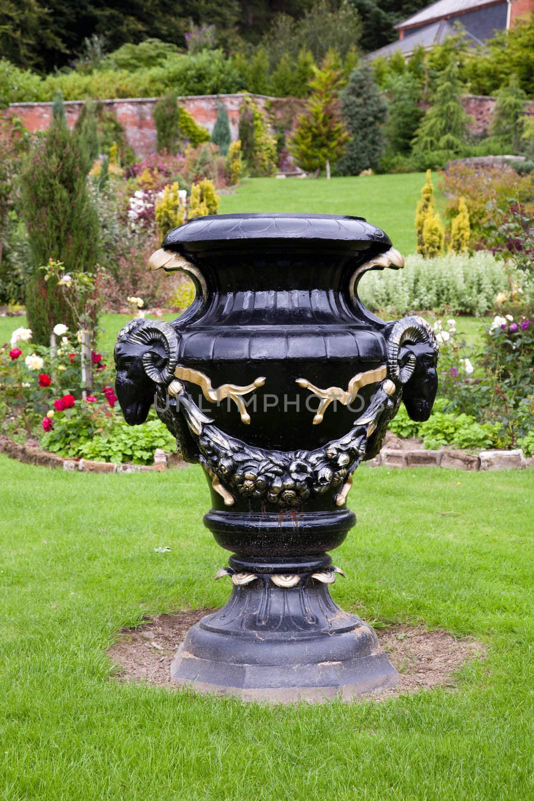 Black and gold painted ornate vase or urn decorated with ram heads