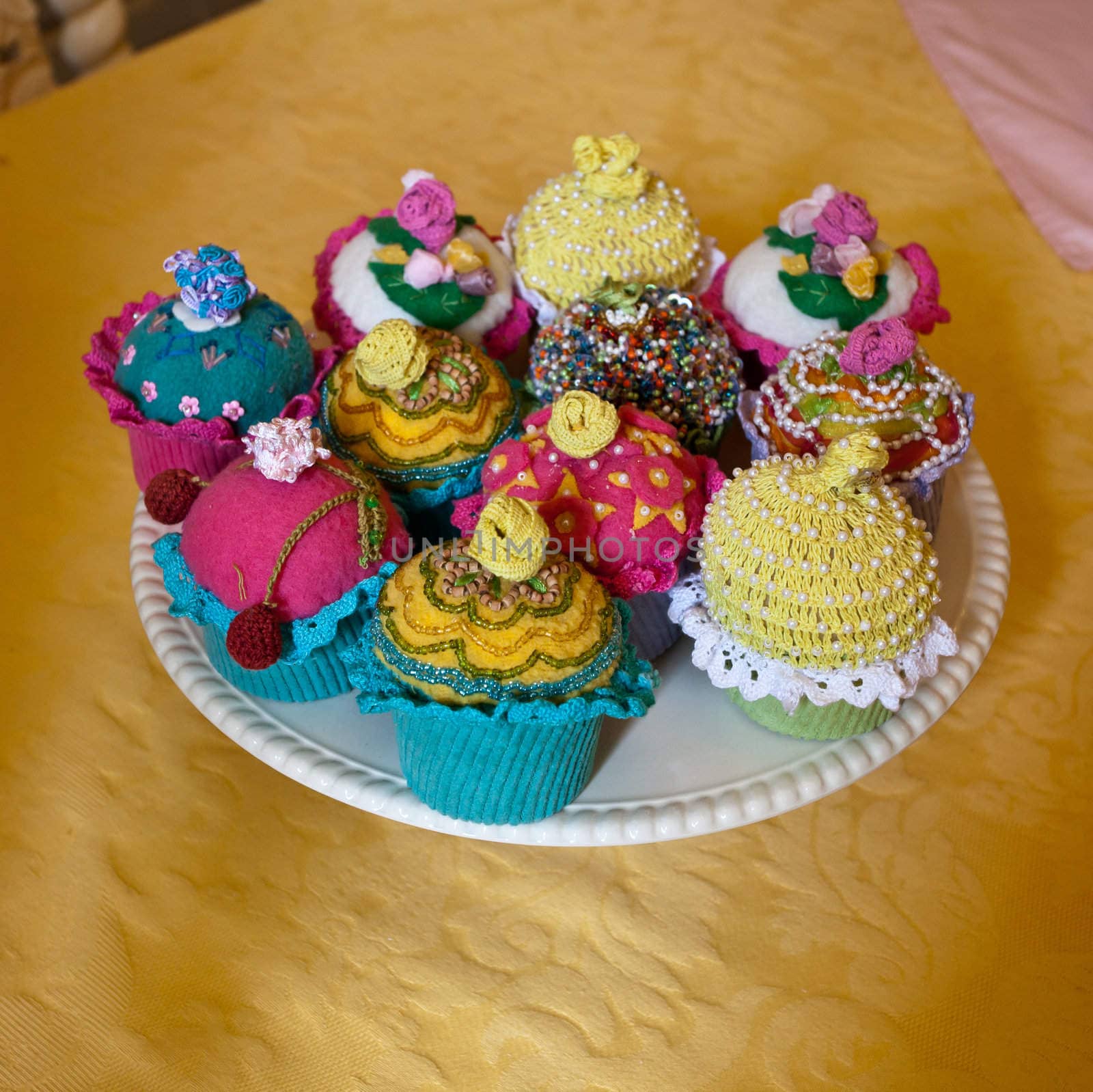 Unusual knitted or crocheted cakes and buns on a white plate